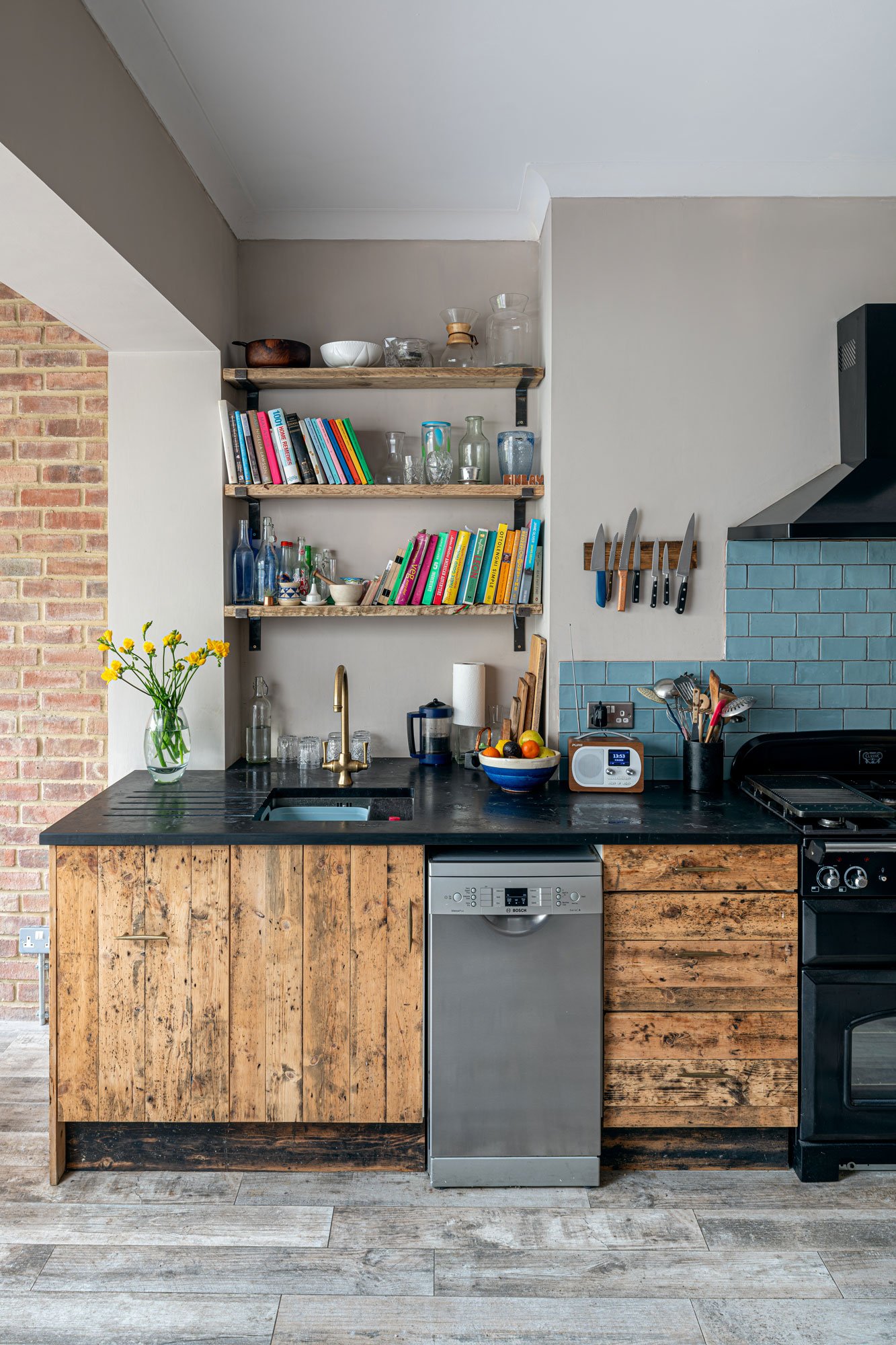 Kitchen area showing units, shelves, sink, dishwasher and range