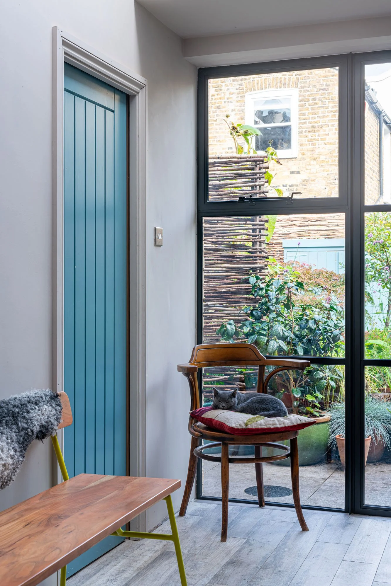 rear extension internal showing chair, wooden door and patio doors - Marjoram Architects 187 Railton Road project
