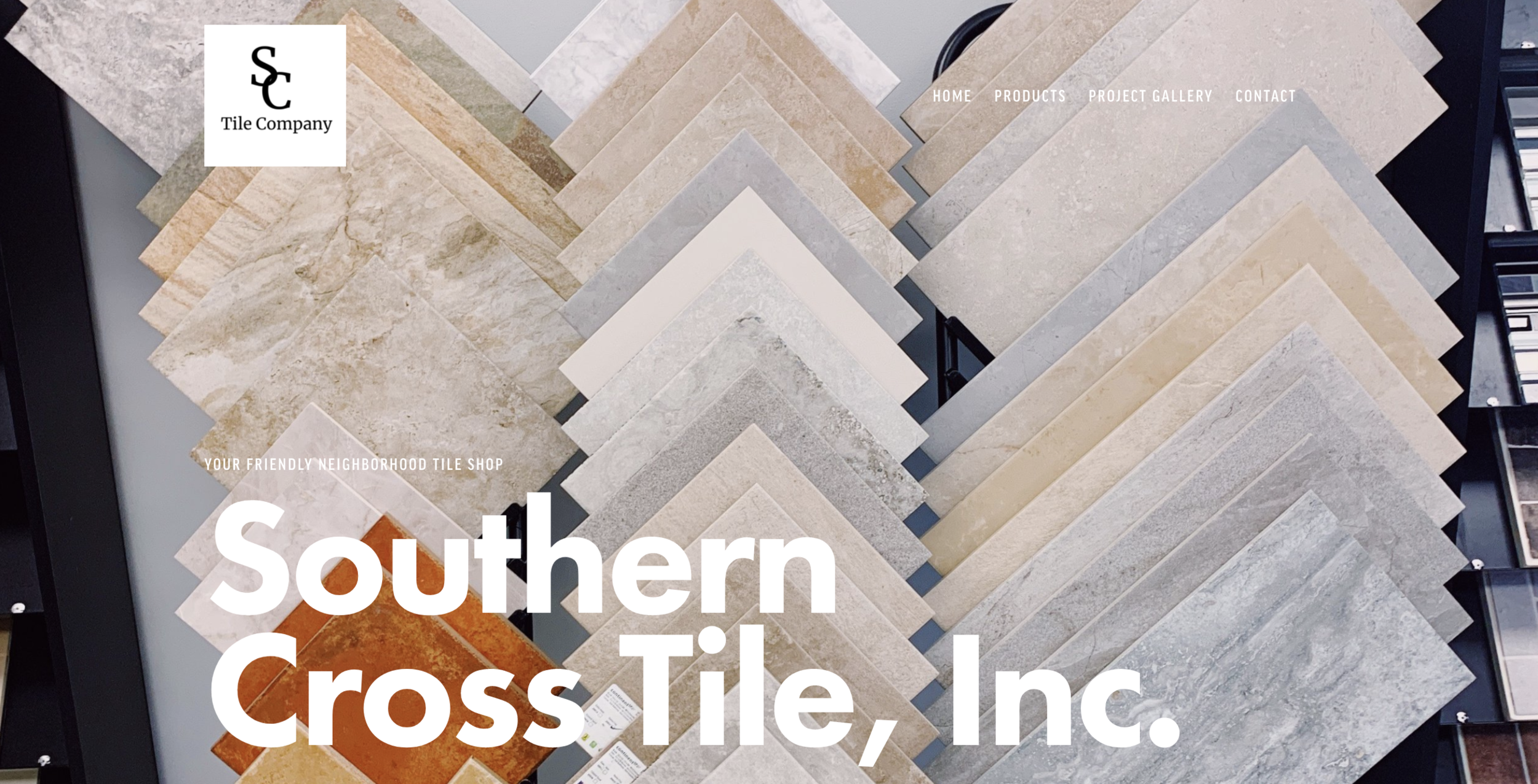 A display of various tile samples in different colors and textures, arranged in a professional showroom setting.