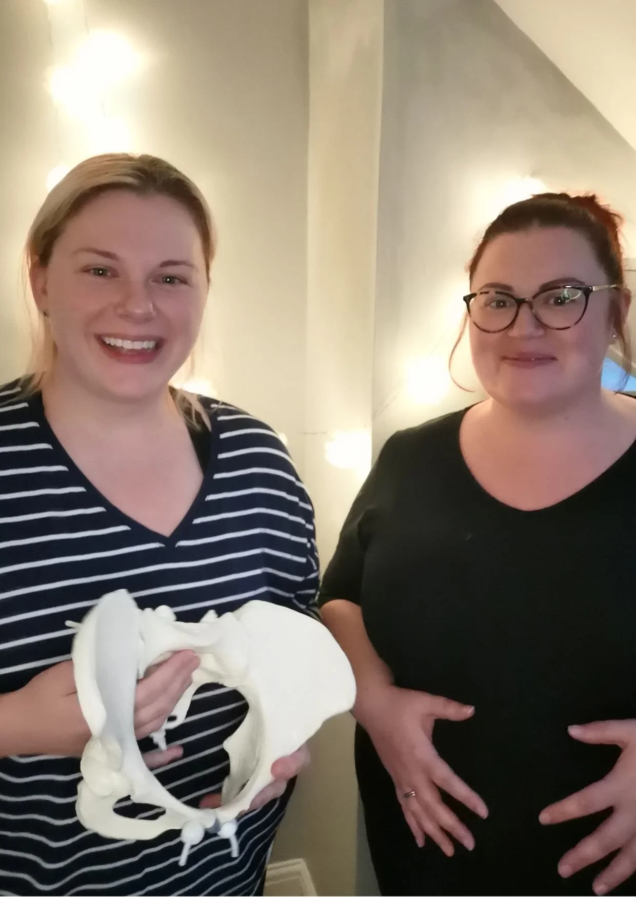 Doula and antenatal educator in Leeds holding pelvic model during antenatal class, supporting a pregnant woman with informed, confident birth preparation.