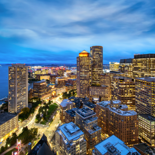 Boston city skyline at night with illuminated buildings and streets near the waterfront