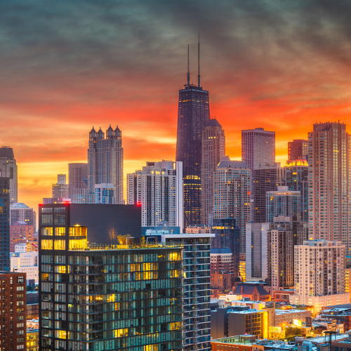 Chicago skyline at sunset with city buildings illuminated under a colorful sky