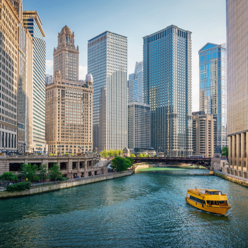 Chicago River flowing through downtown with skyscrapers and a yellow water taxi on the water
