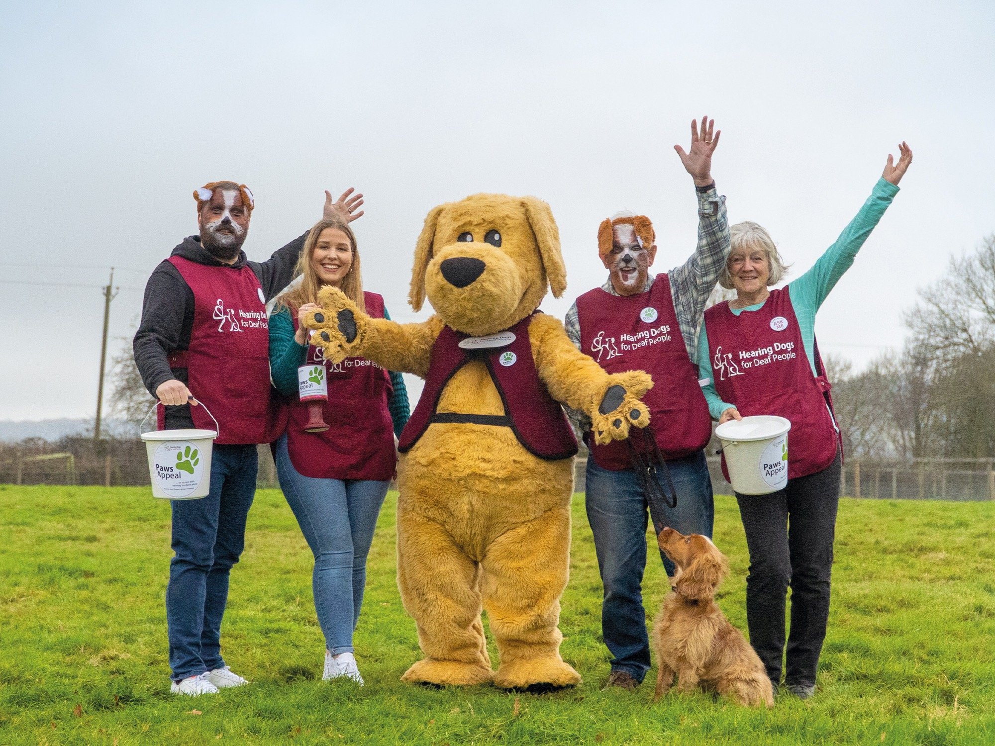 Four fundraisers with a hearing dog and someone in a large dog costume, all raising money for the charity