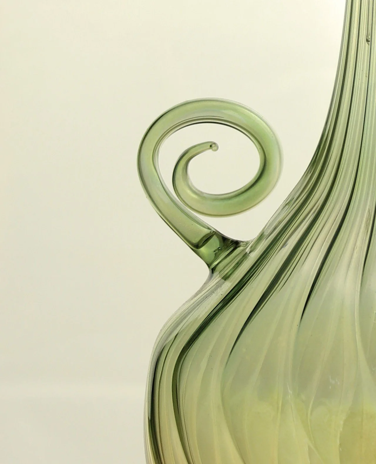Detalle de una botella de cristal verde con un diseño en espiral