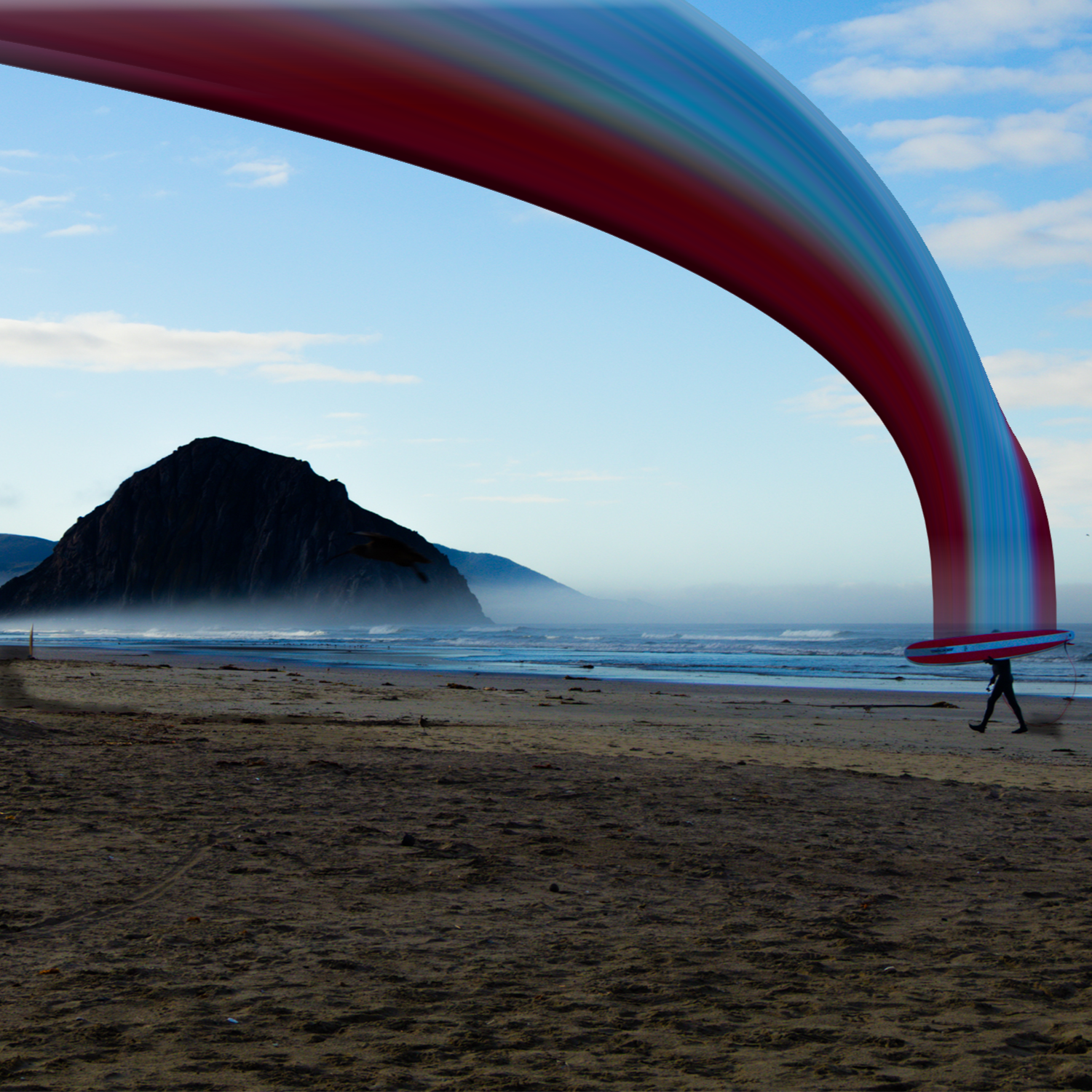 A beach scene with a person carrying a surfboard and an umbrella. A large, colorful rainbow-like arc stretches across the sky, with a mountain in the background and the ocean in the foreground.