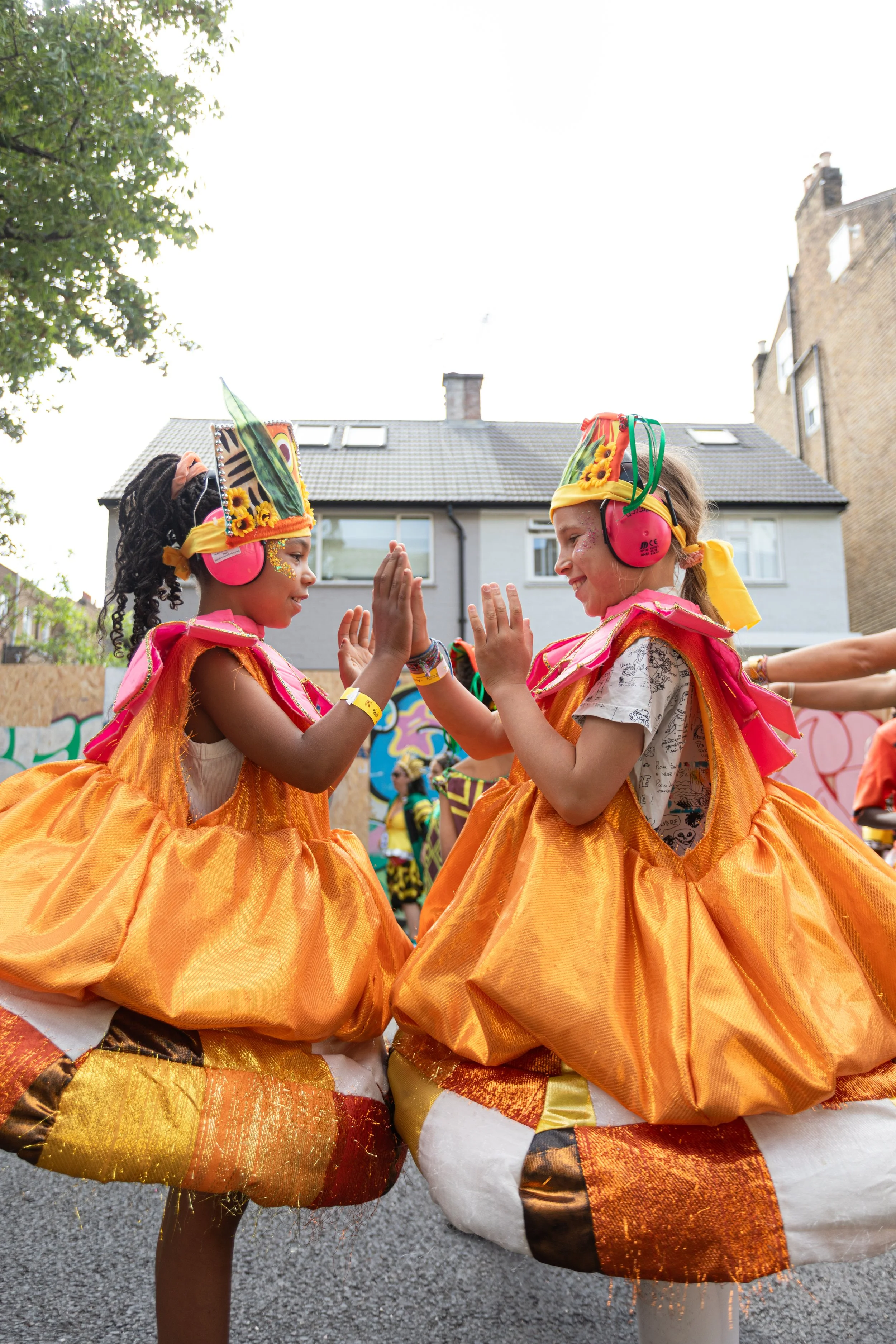 Two young performers play a handclapping game 