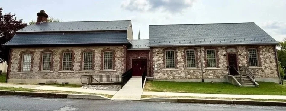 Two brick and stone buildings joined by small connector, front view