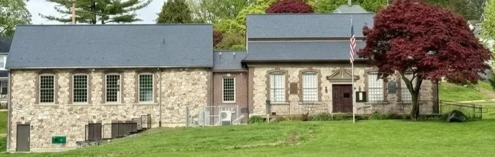 Two brick and stone buildings joined by small connector, back view