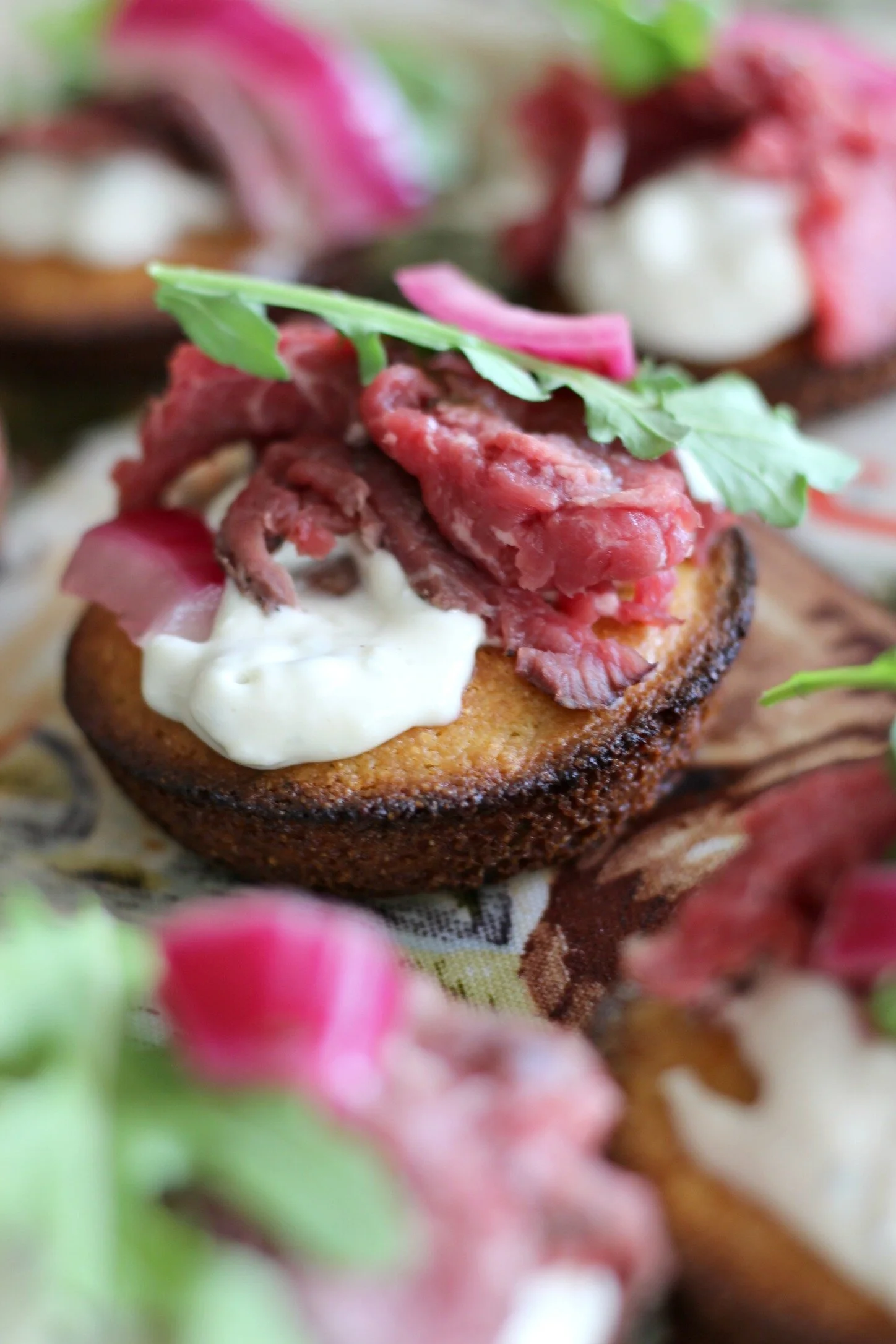 Beef Tenderloin Cornbread Crostini with Horseradish Blue Cheese Sauce