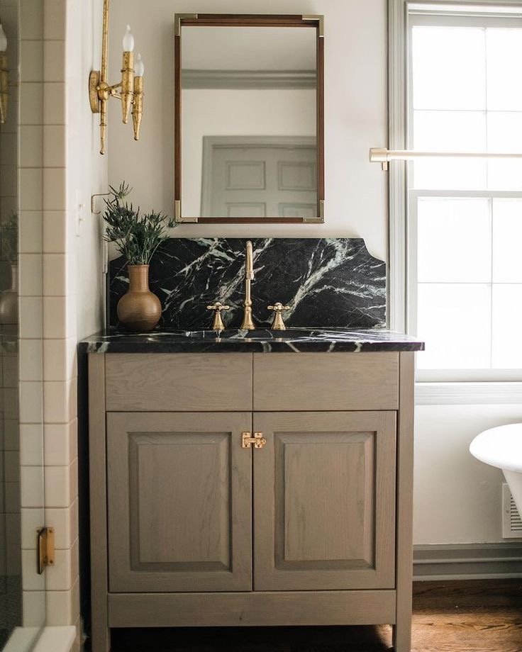  Another example of a high backsplash extending from the countertop. I love this countertop material as well.  I also loved the unconventional placement of the sconce off to the side. 
