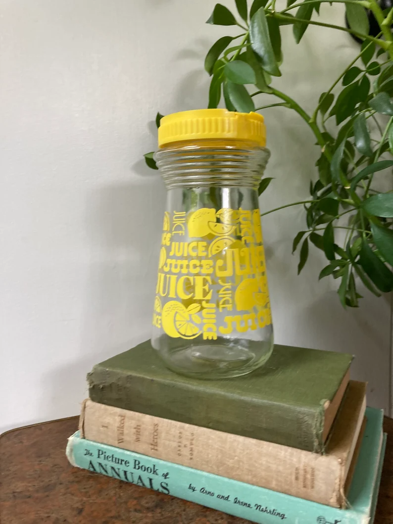 Glass juice container with yellow plastic lid.png