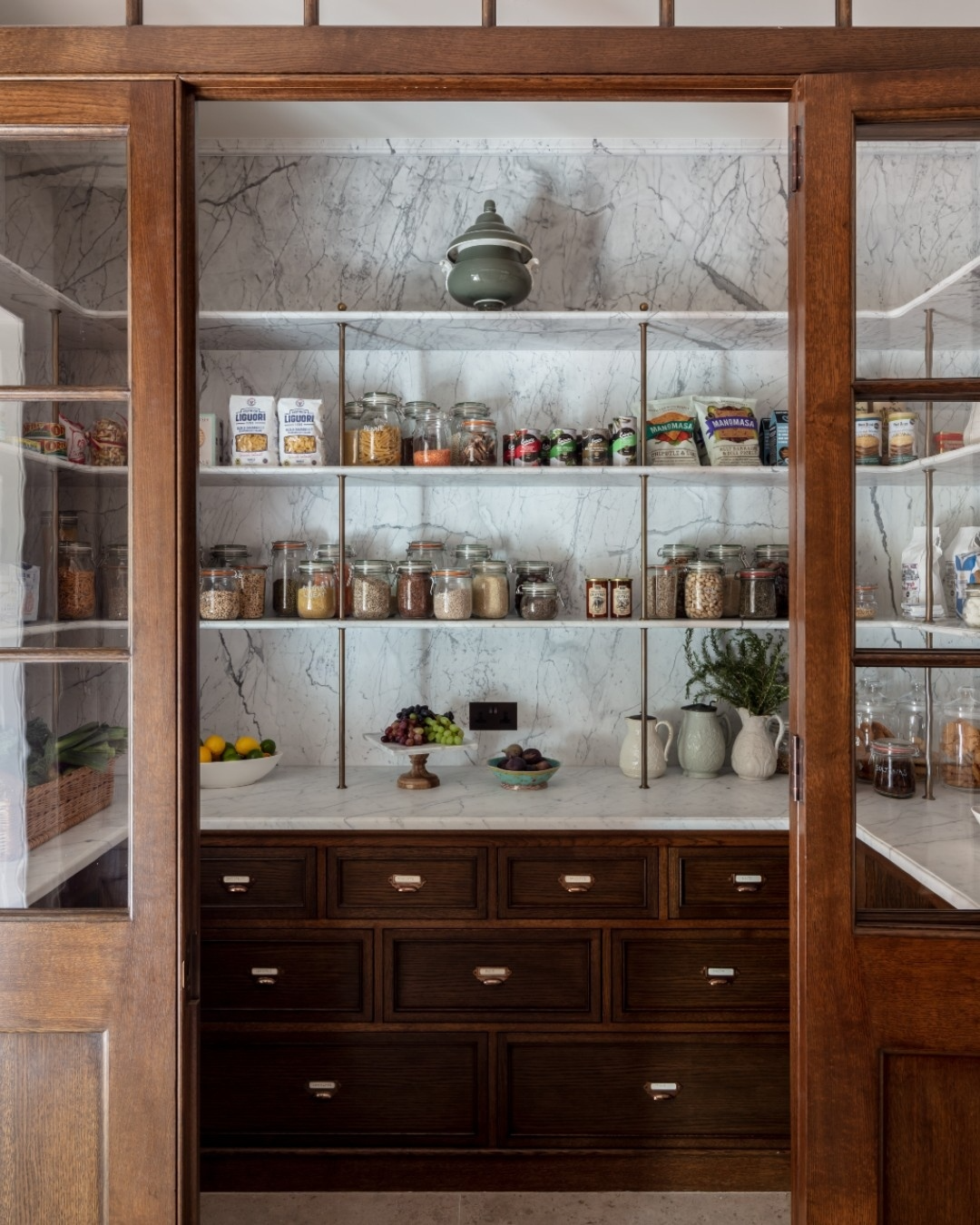 I adore the marble and wood combo and the open shelving above those lower cabinets full of drawers.
