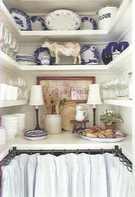 Skirted lower cabinets with open shelving above and lots of country cottage details.