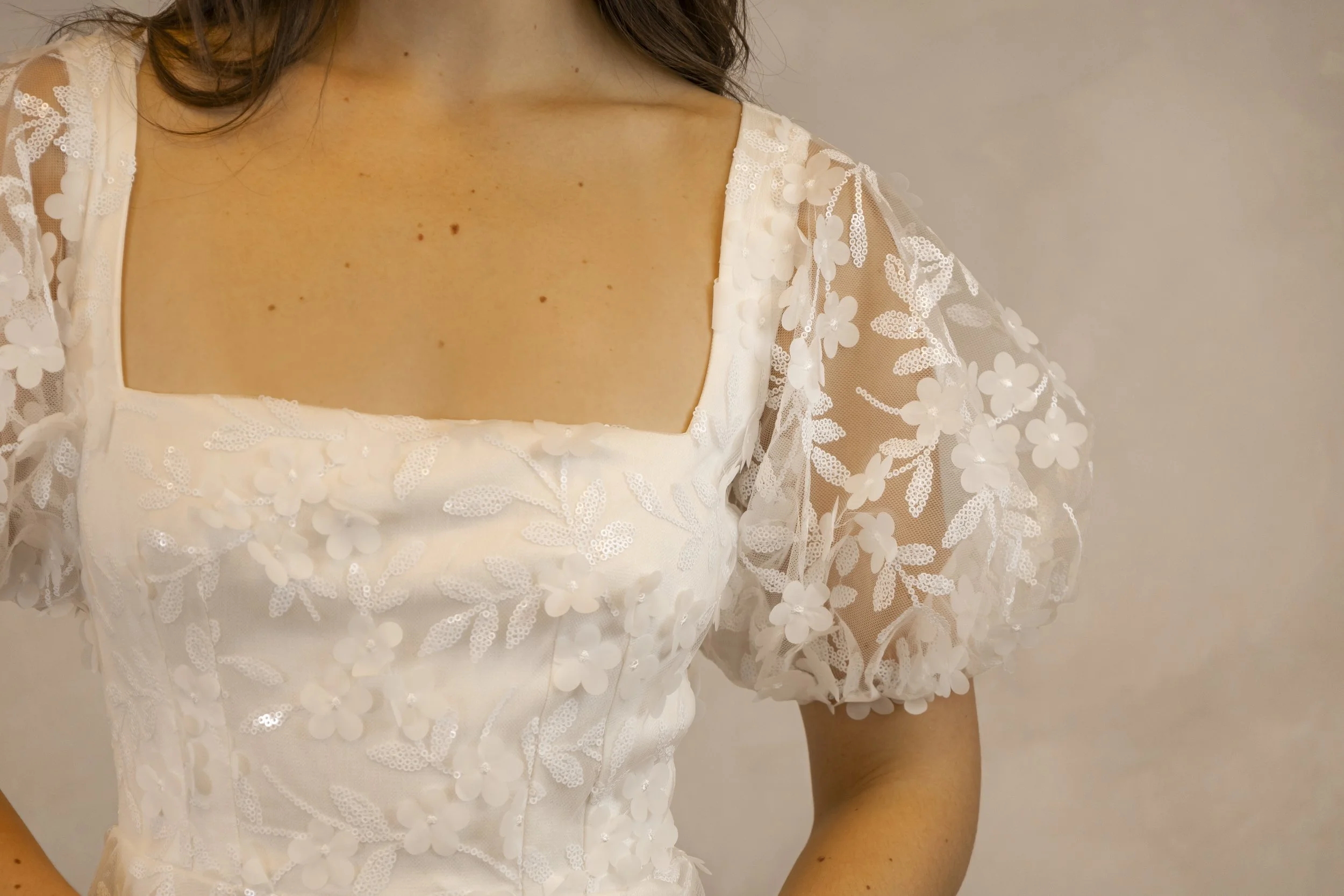 Lace wedding dress with a hint of sparkle and square neckline. Finished with a short puff sleeve.