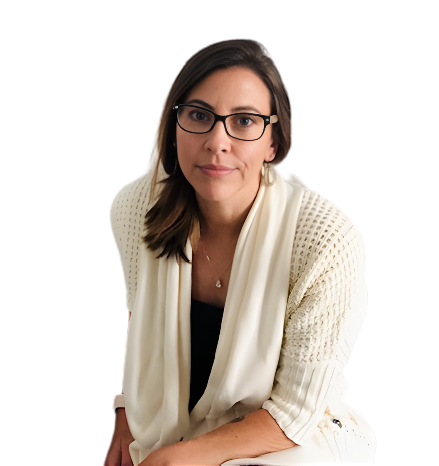 A woman with brown hair, glasses, and fair skin, wearing a cream-colored knit cardigan over a black top, sitting with her hands resting on her lap, looking at the camera.