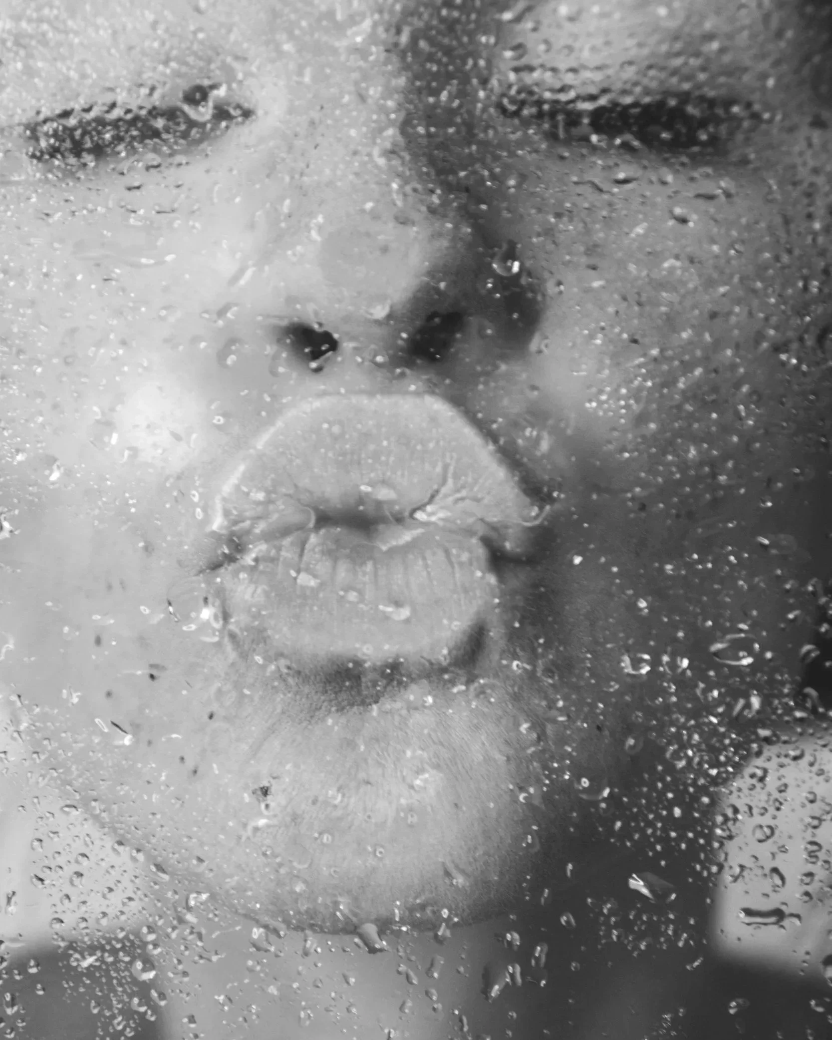 a woman kisses a glass shower door her skin is hydrated and she is happy