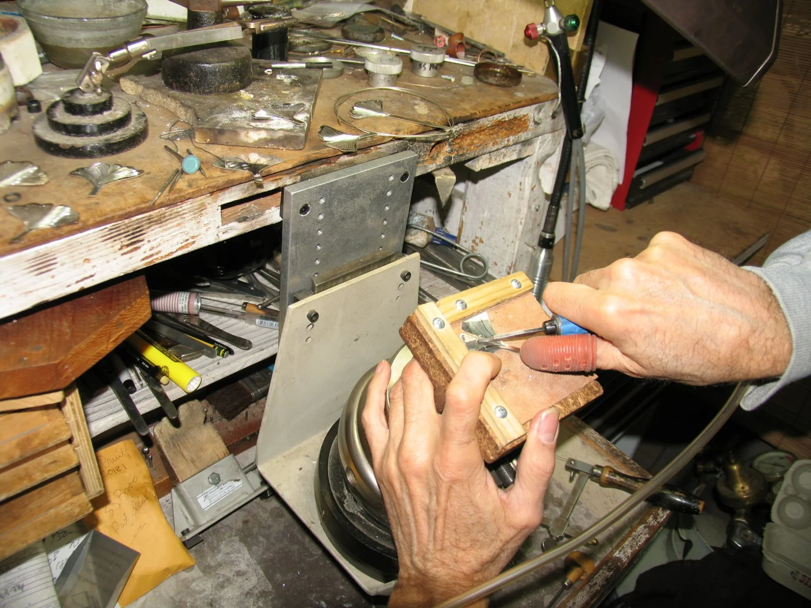 Master gold smith Larry Stark working on his bench on a piece of custom jewelry in his studio in Sacramento