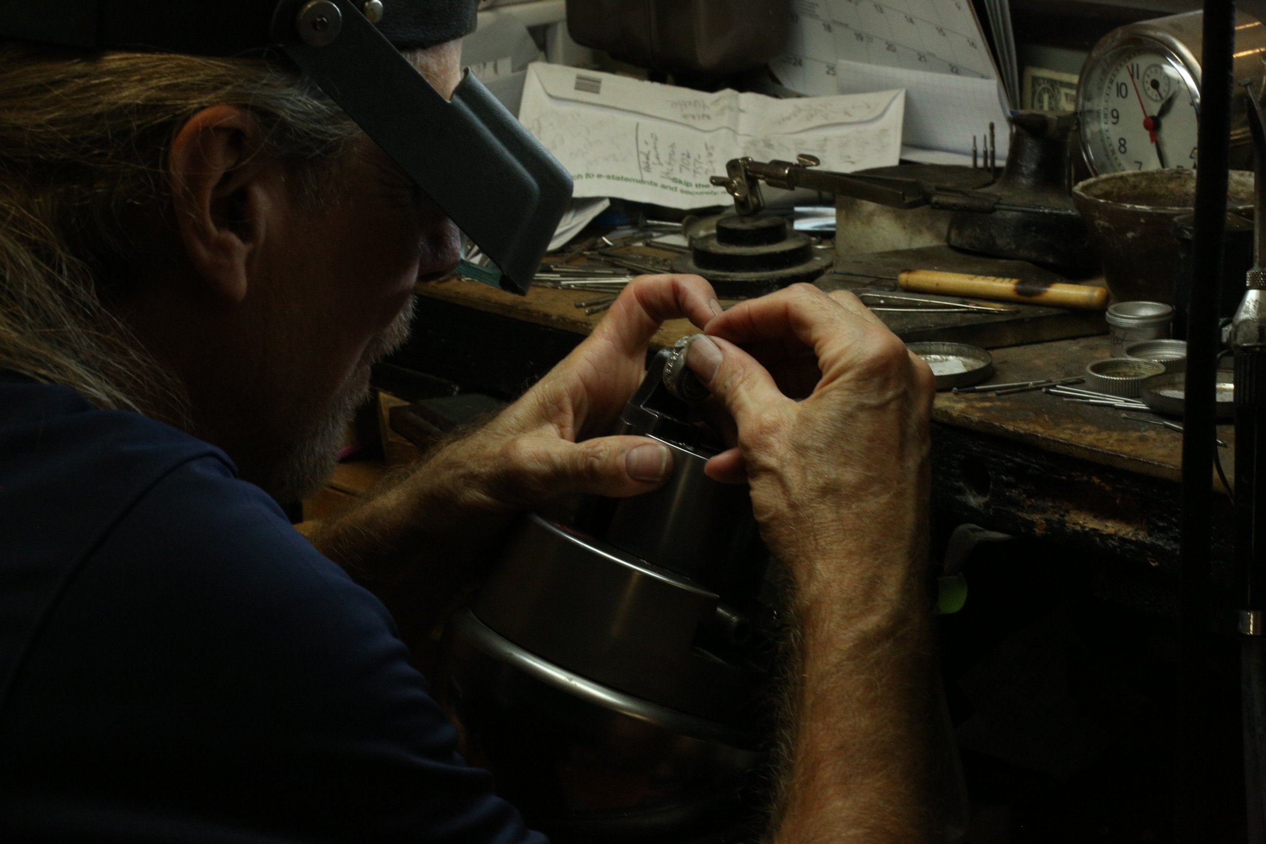 Master gold smith Larry Stark working on his bench on a piece of custom jewelry in his studio in Sacramento