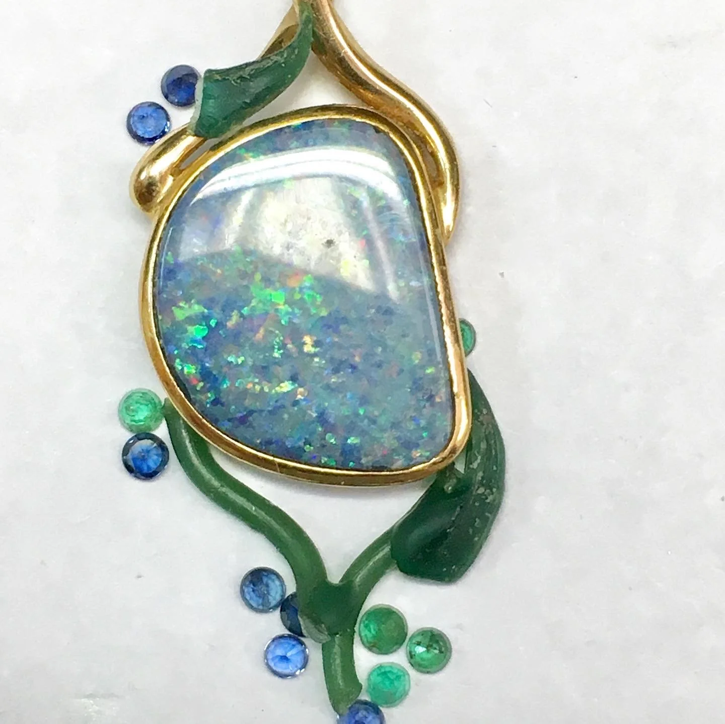 In Stark Jewelers, we collaborate closely with our client, drafting sketches and creating a custom wax design for them to approve. we decided to pull the natural colors out of the opal by accenting it with a dazzling array of sapphire and emerald.
