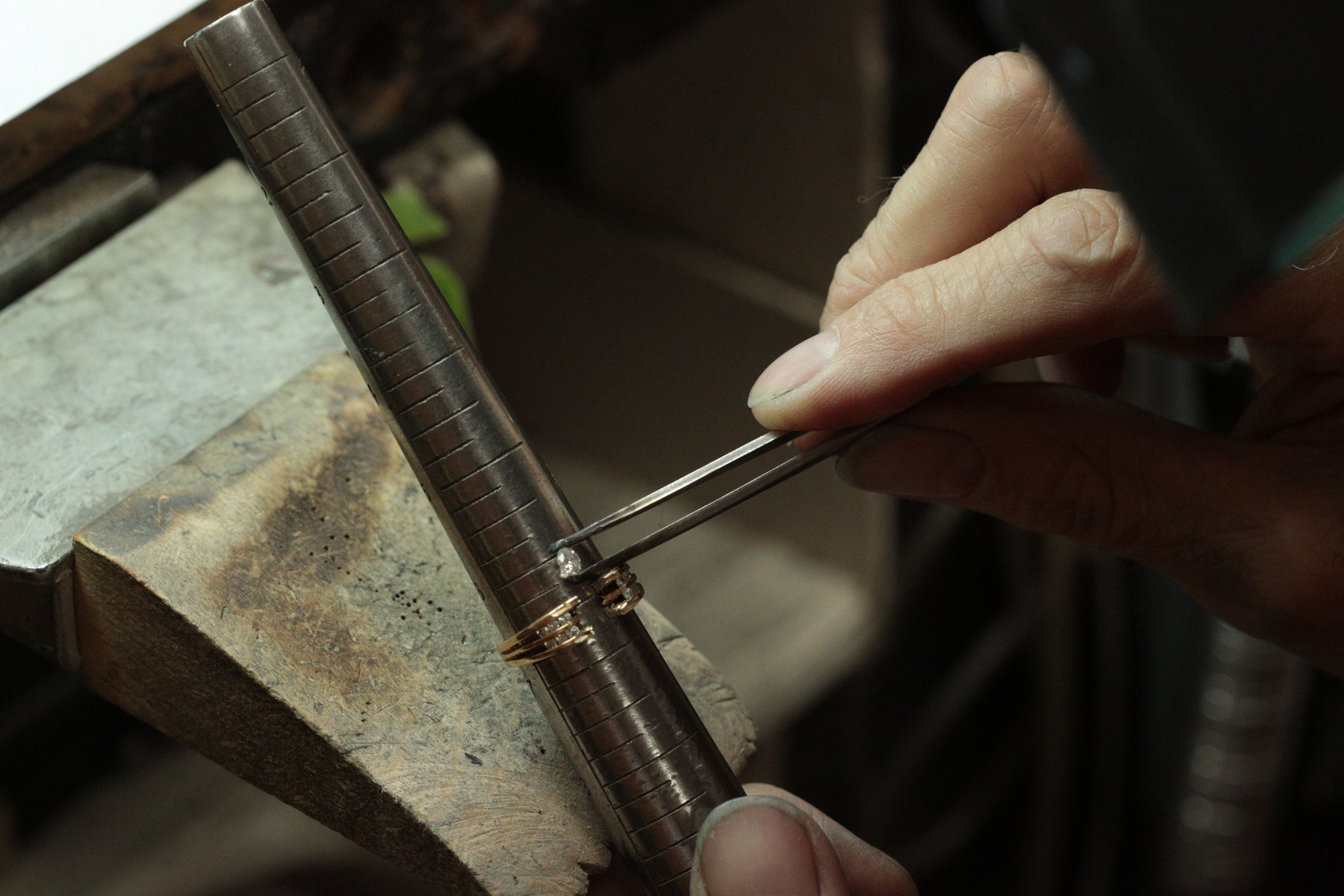 our master jeweler carefully cutting into the original yellow gold setting to safely release the diamond at Stark Jewelers in Sacramento