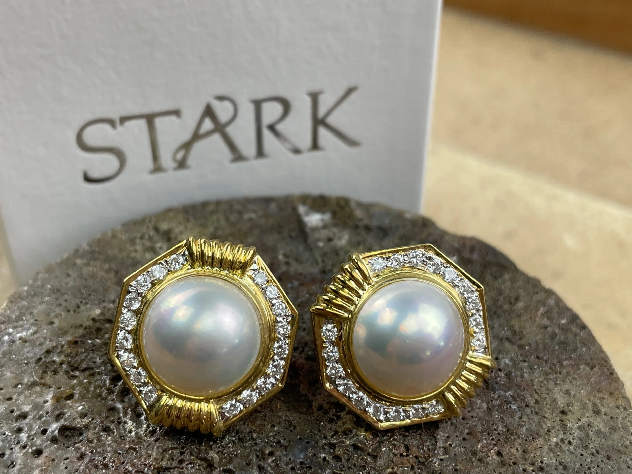 Pair of art deco style gold earrings with large pearl center and surrounding small diamonds designed and handmade by Stark Jewelers