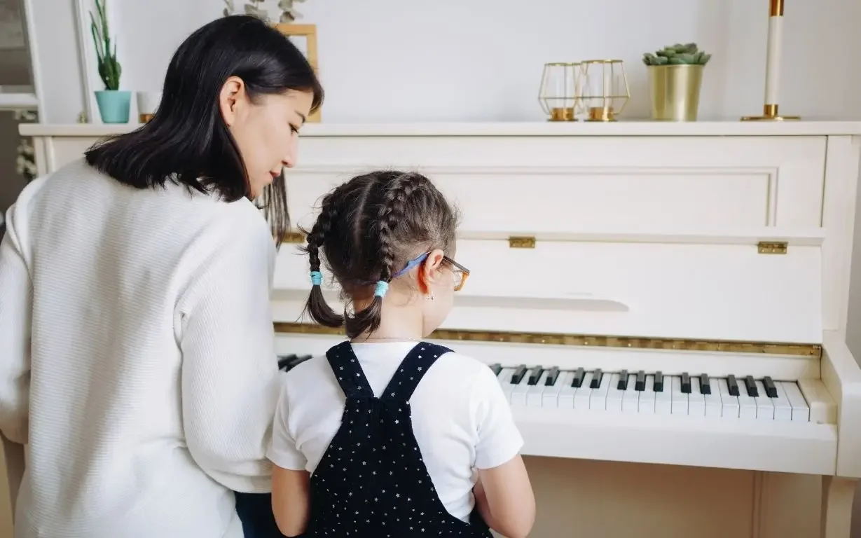 piano teacher teaching piano to kids