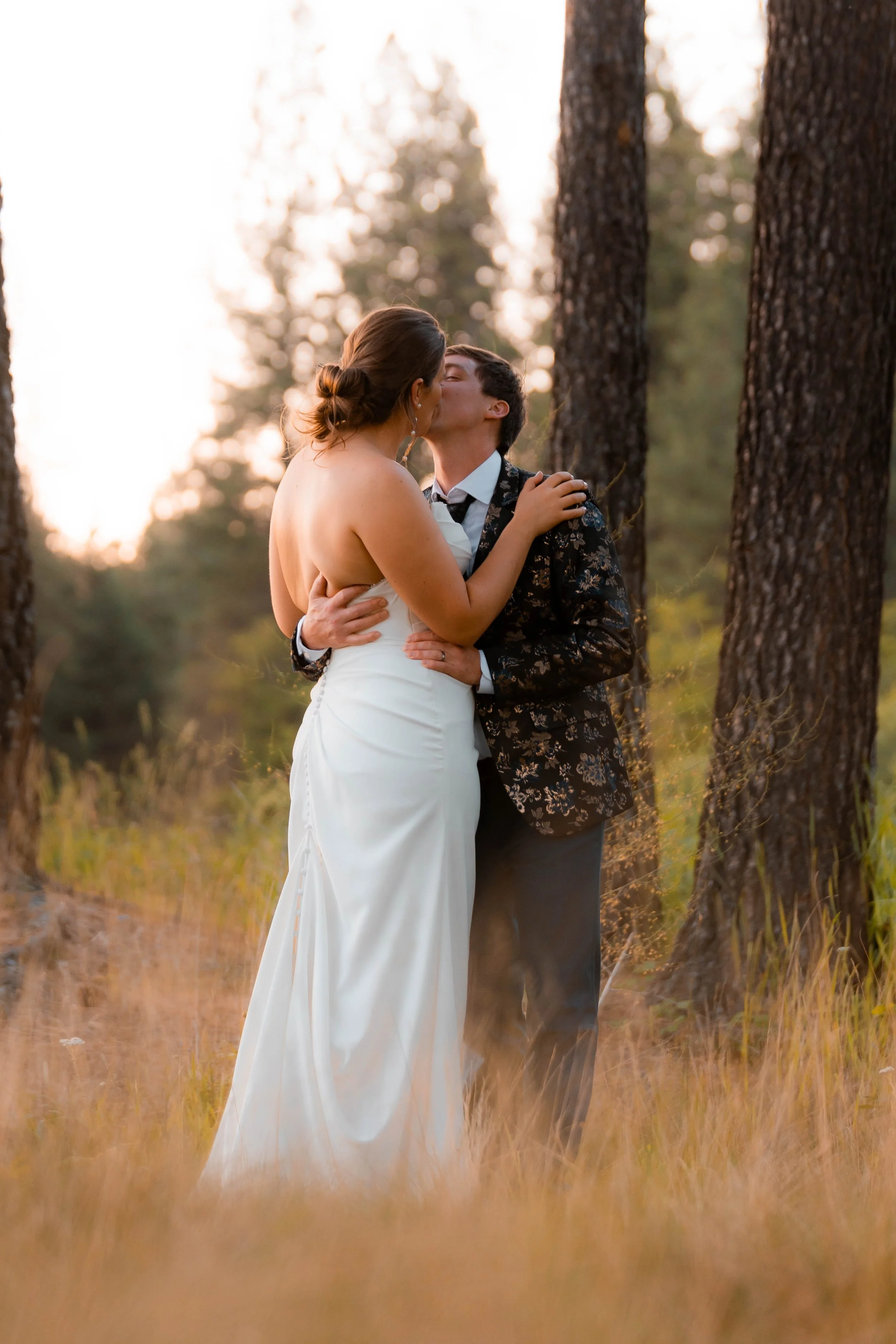 Couple on their wedding day embracing at sunset in a forest, captured by LaFleur Photography in Coeur d’Alene.