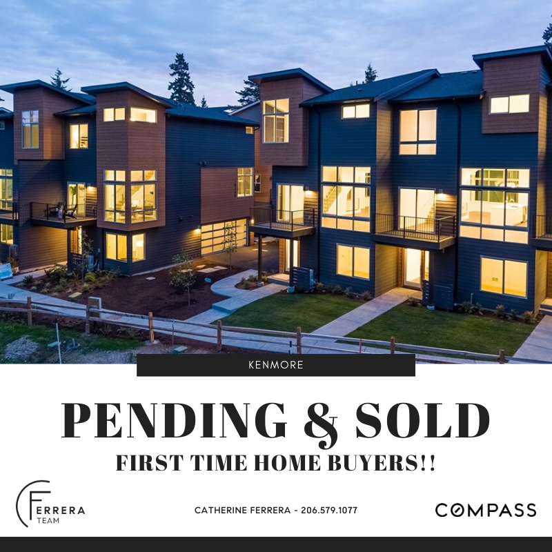 Modern multi-story residential building with illuminated windows during evening, surrounded by landscaped area and walking paths.