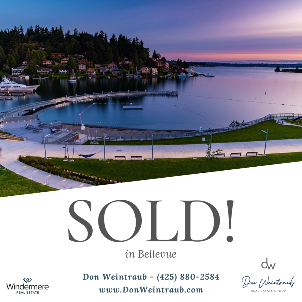 A waterfront with houses on a hill, a marina with boats, and a park with walking paths at sunset, with a 'Sold!' sign for real estate.