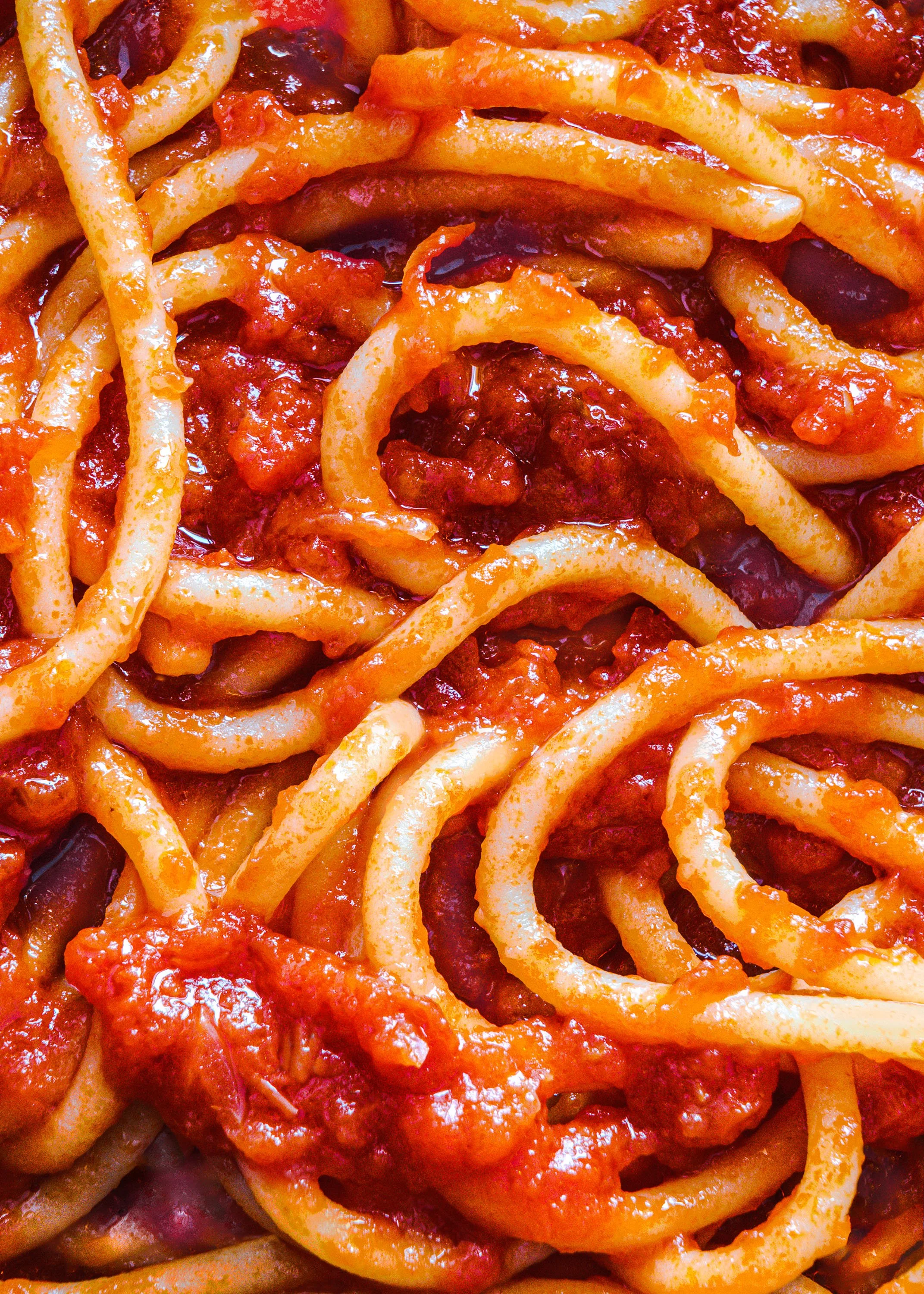 Spaghetti con salsa di pomodoro, pezzi di pomodoro e condimento.