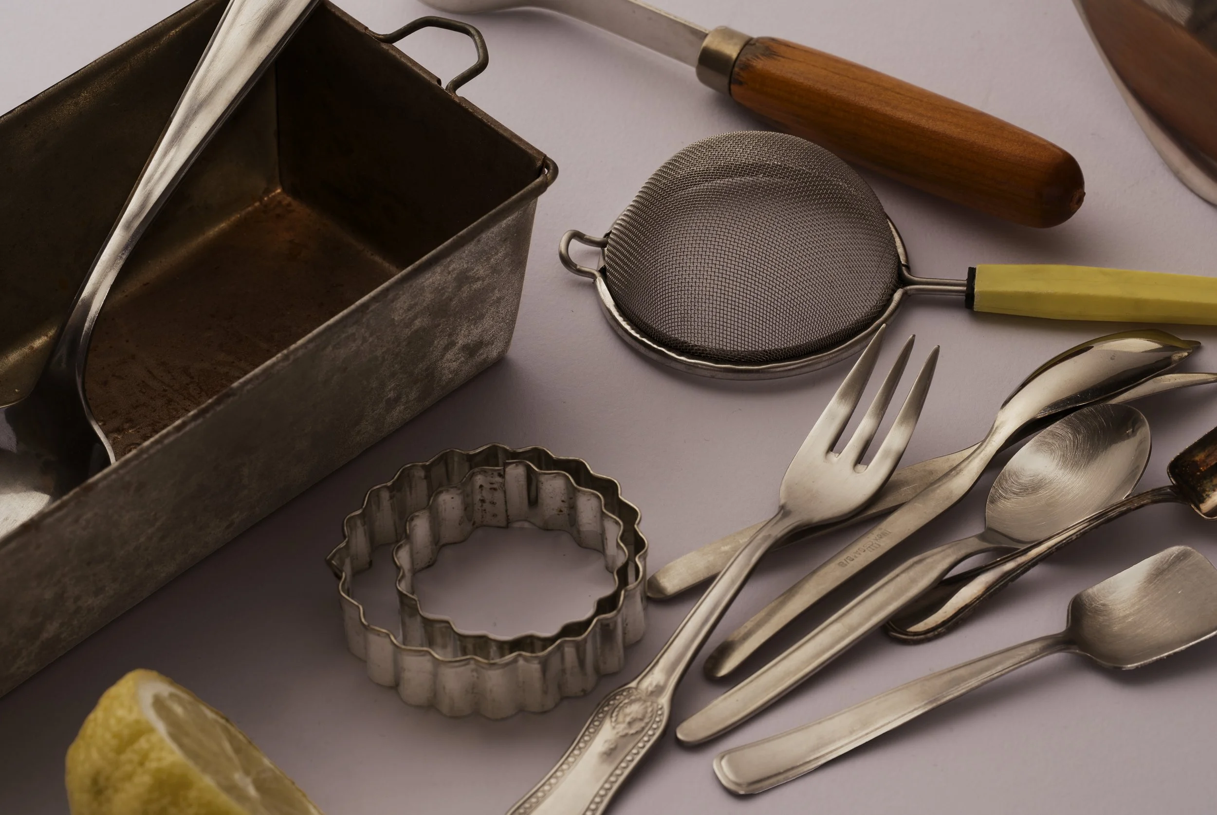 forchette-colino-burro-teglia-limone-cucchiai-formine-riflesso-metallo-acciaio-astratto-fotografo-food-milano.jpg
