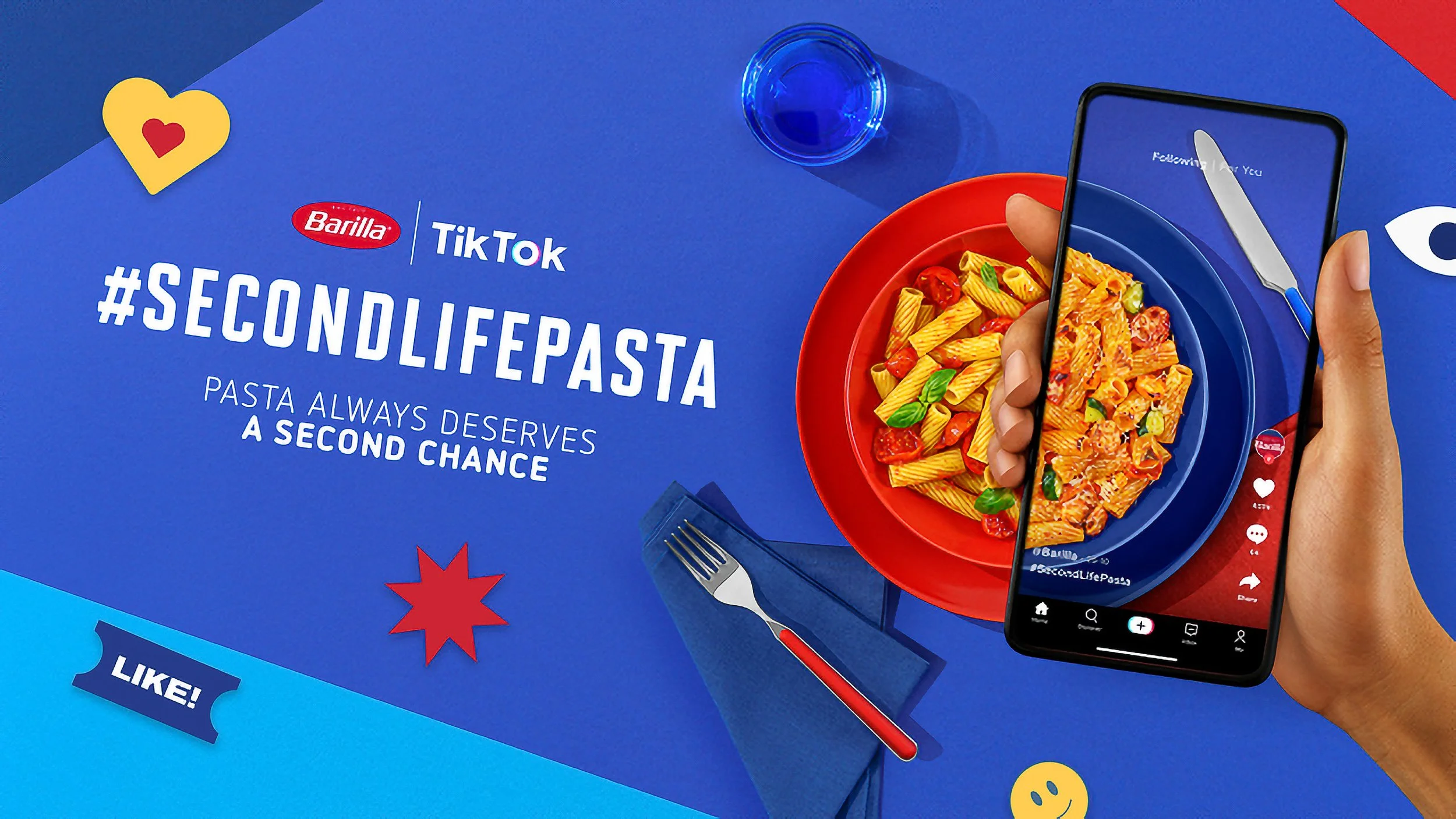 Immagine di un poster pubblicitario per Barilla e TikTok con il hashtag #SECONDLIFEPASTA, mostra due piatti di pasta con un telefono che registra il piatto, ed elementi grafici colorati come cuore, stelline e faccine sorridenti.