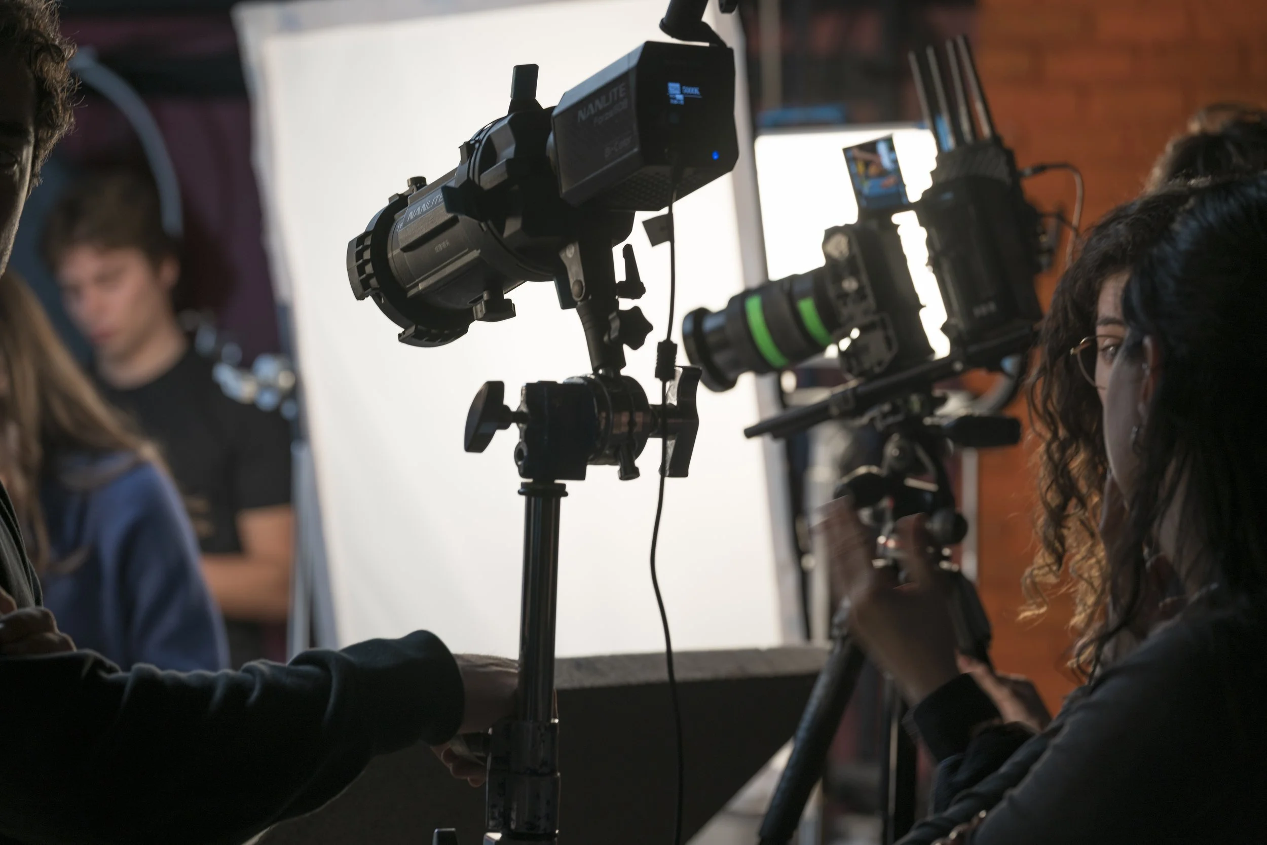 Operatore di produzione cinematografica con videocamera professionale in studio di regia.