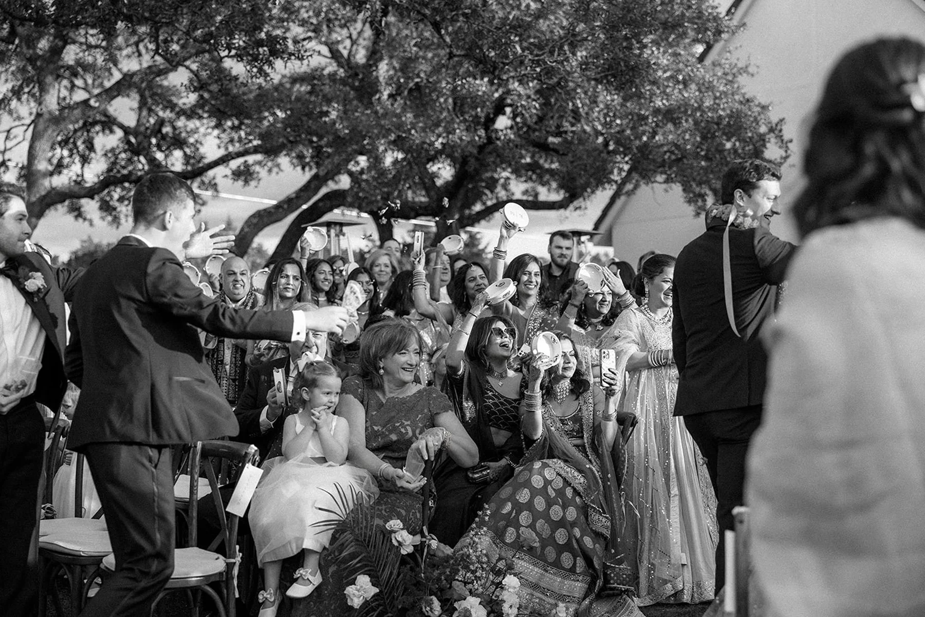 black-and-white-photo-guests-celebrating-ceremony-exit-tambourines-wedding-planner-and-wedding-coordinator.jpg