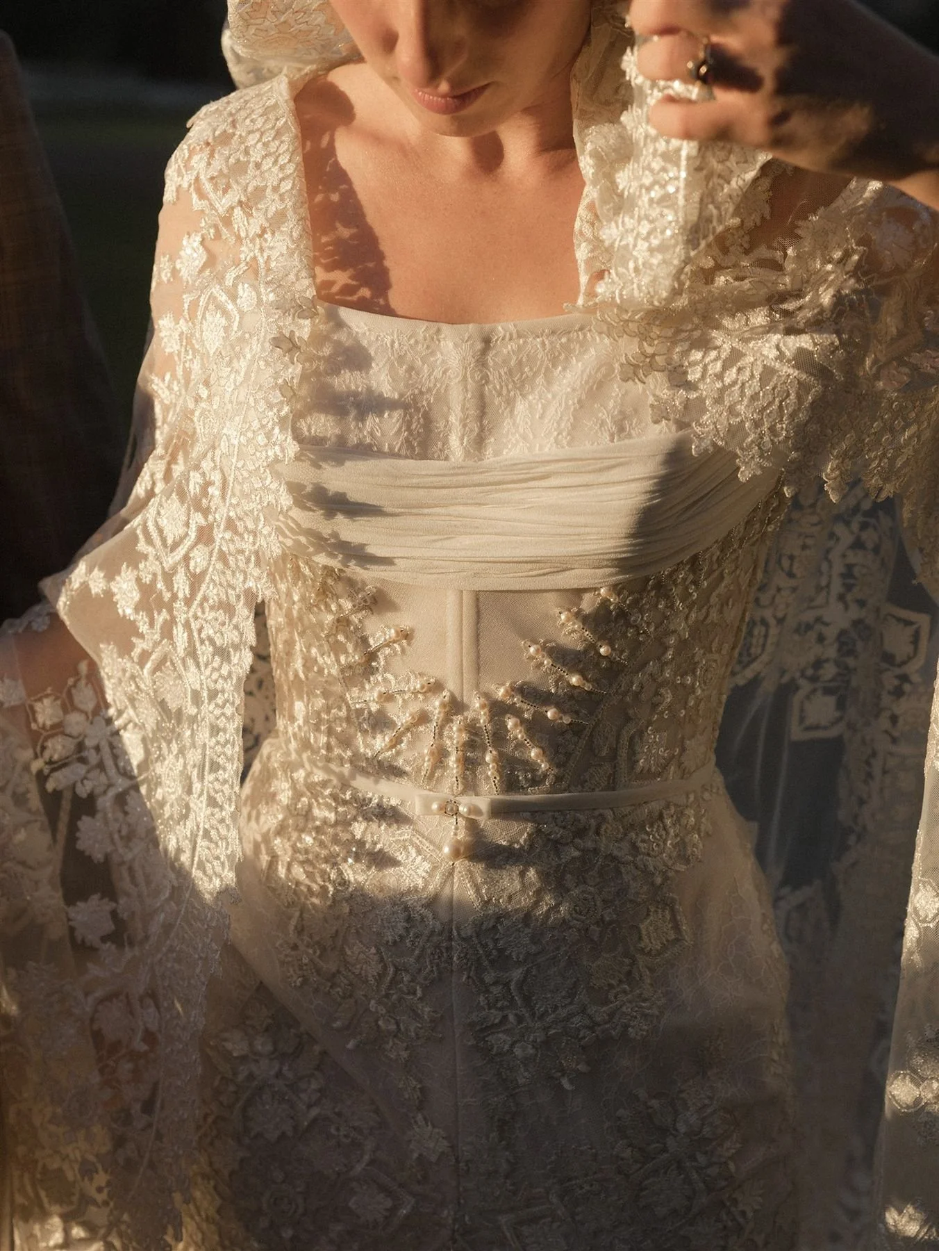 Couture bridal dress and bridal cape with intricate beading, lace and boning details with moody sunlight - epoch co wedding planners austin tx