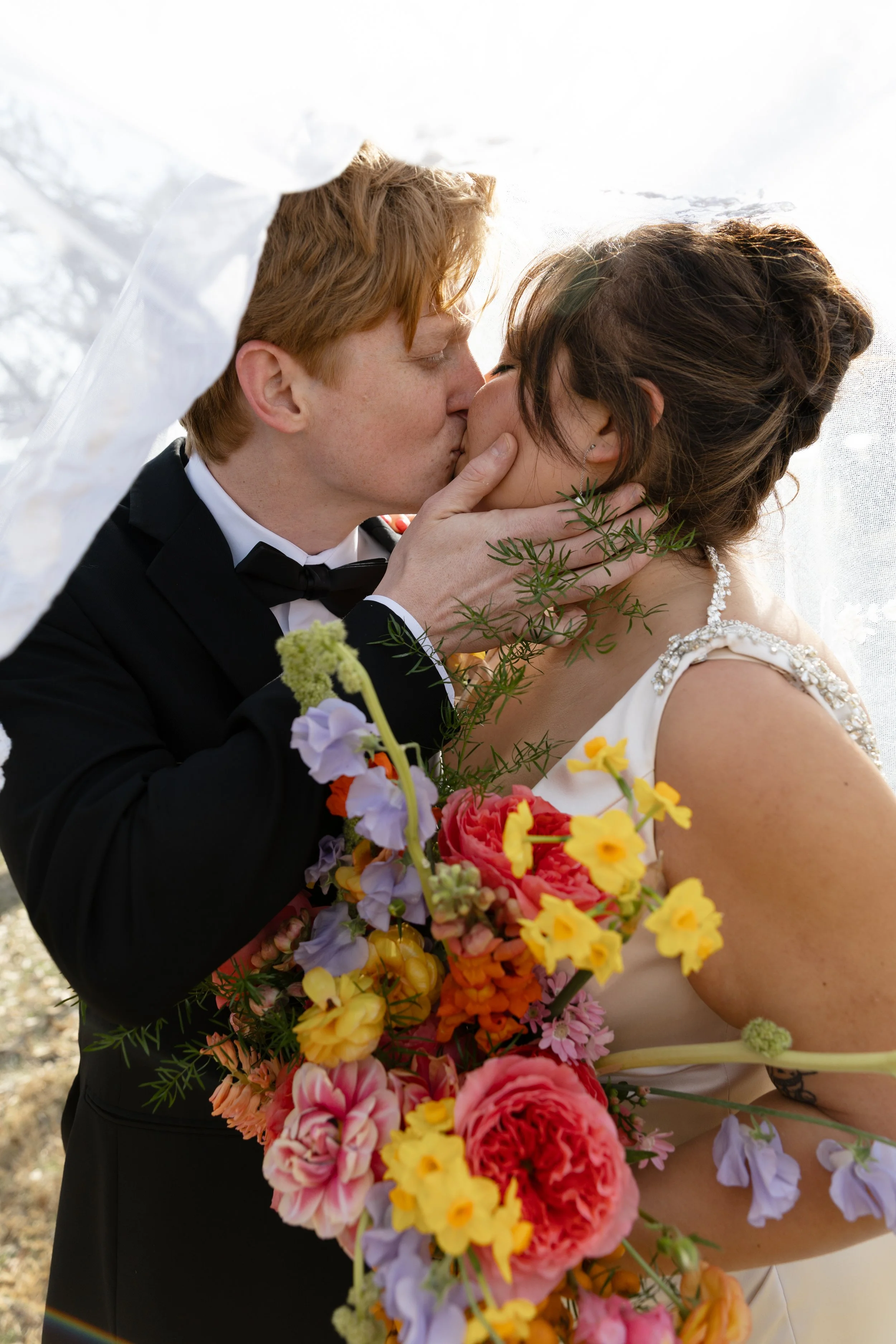 Newlyweds kiss at colorful Hill Country wedding