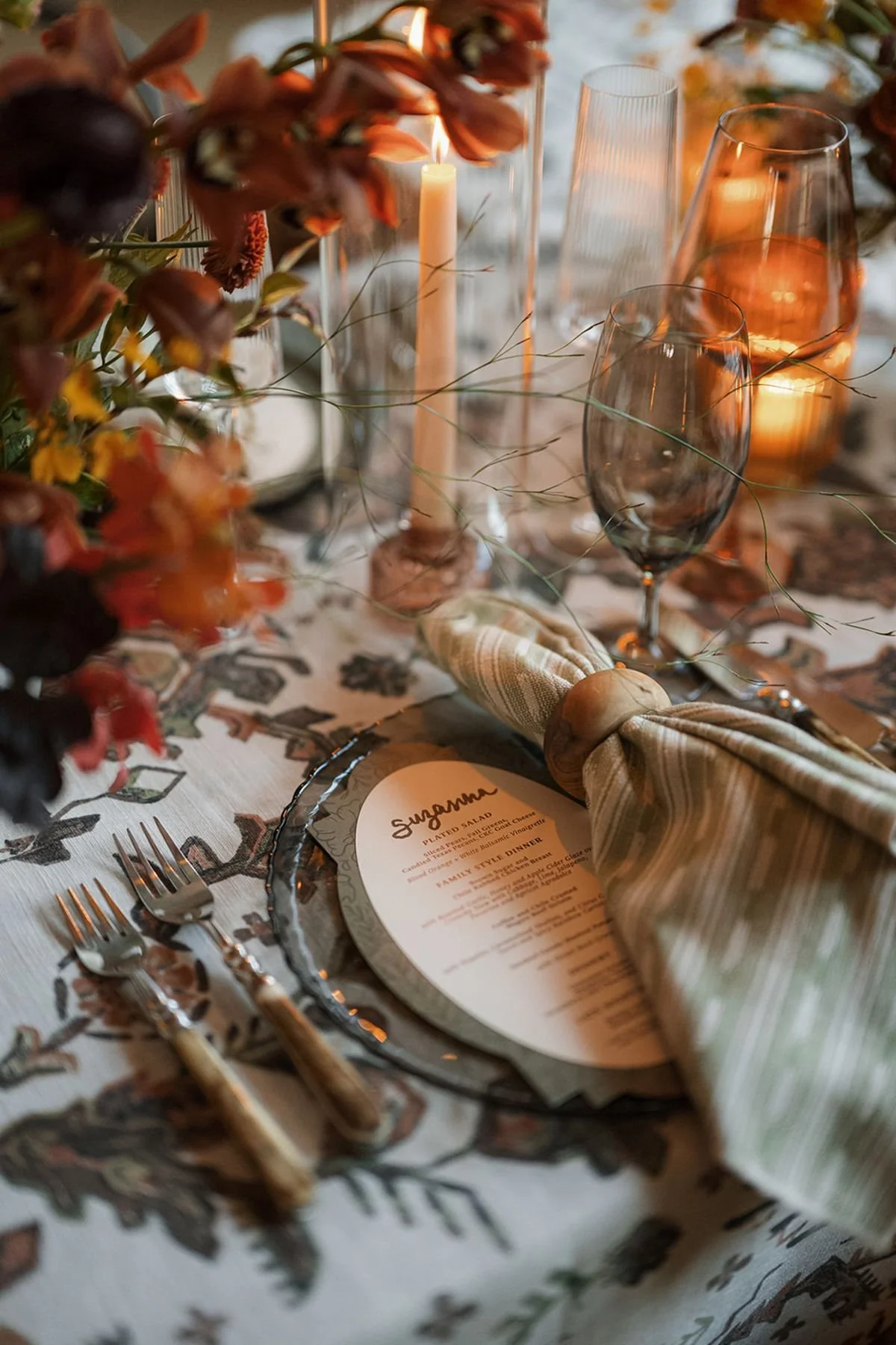Ranch wedding with rustic patterned linen, green glassware plates, bone flatware, Smokey glassware, warm amber candles, green Aztec printed napkins and burgundy rich fall leaves by wedding planners and wedding coordinators epoch co