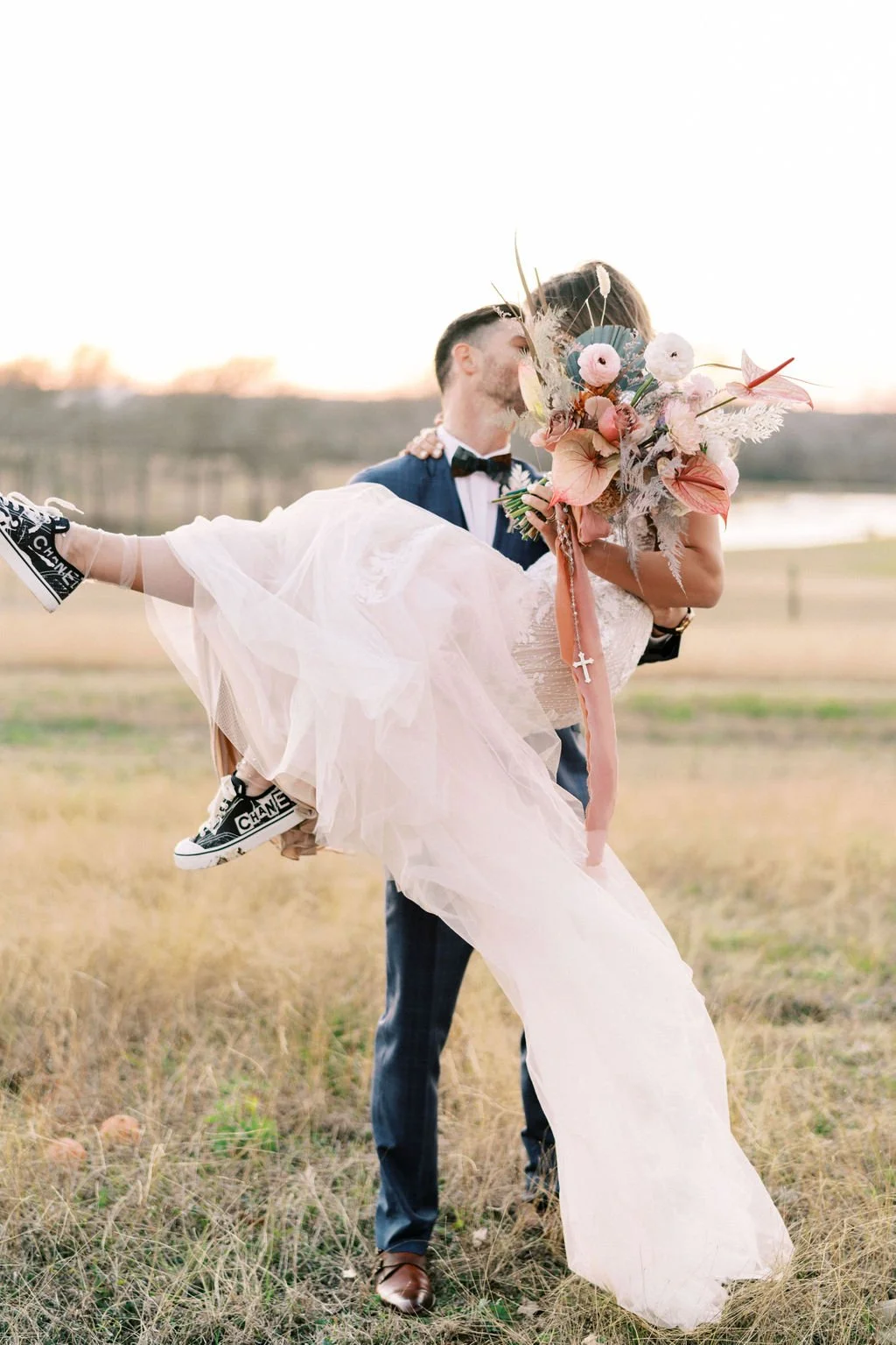 Pastel pink wedding dress with pink floral bouquet and coco Chanel bridal sneakers by unique wedding planners in austin tx