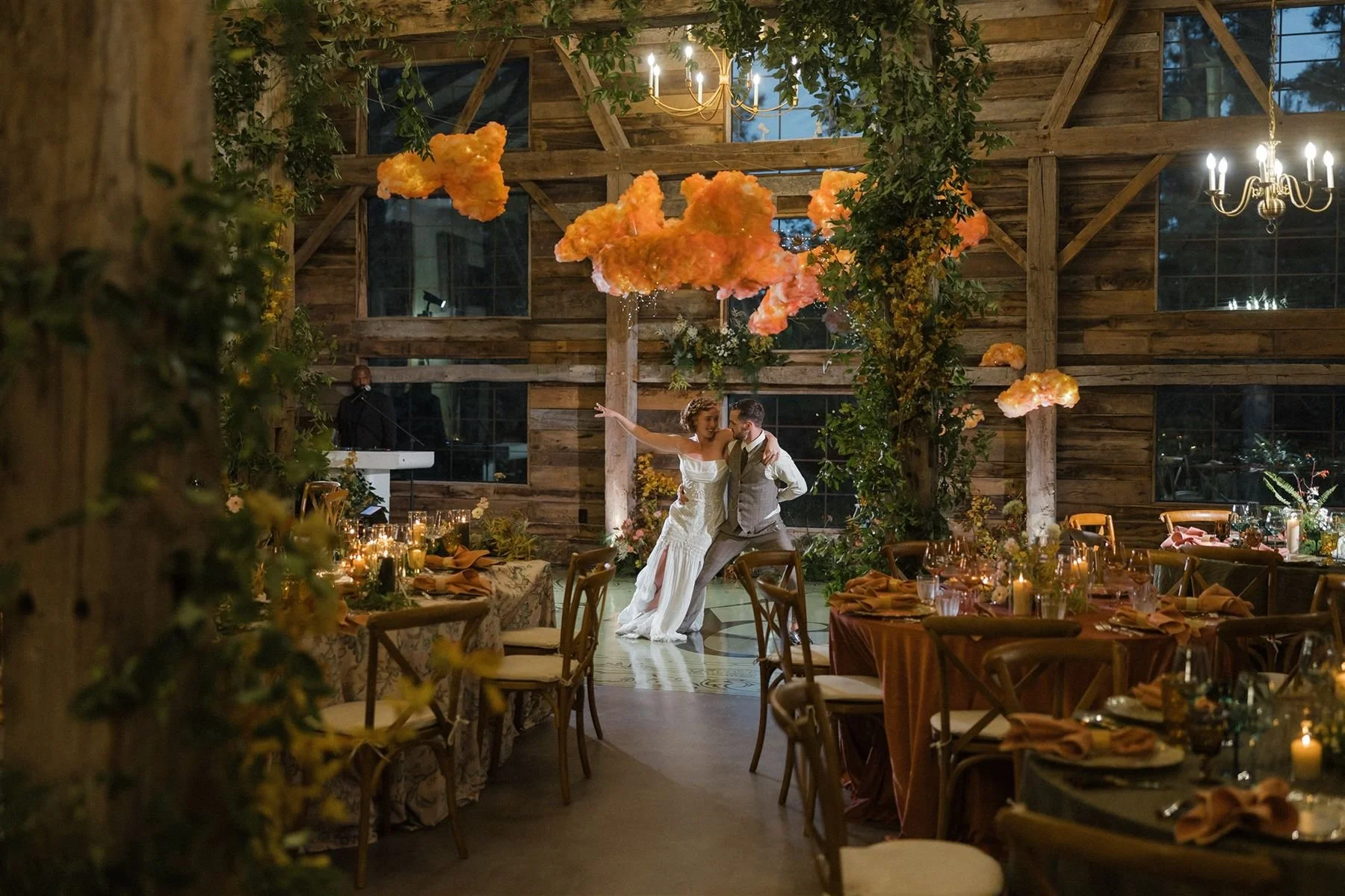 Woodland whimsical wedding design at historic hill house wedding venue in north houston with custom pink and peachy cloud install. Couple side by side leaning into each other for first dance