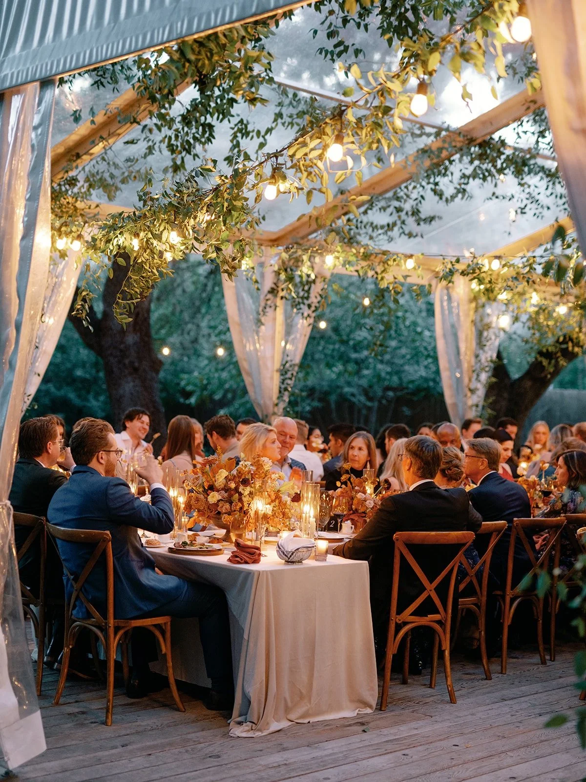 Tented dinner reception by destination wedding planners in austin texas epoch co - fall, orange, blue
