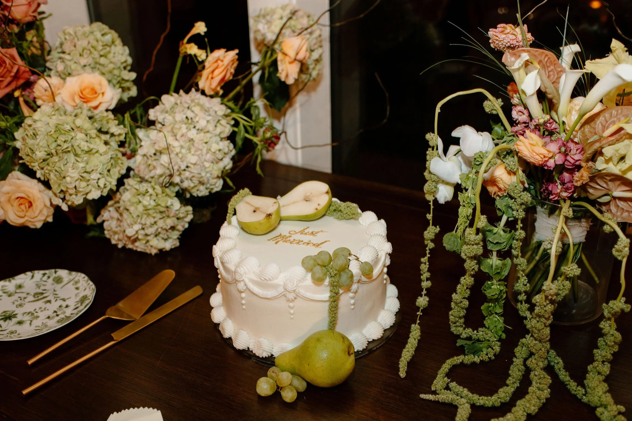 Pear-inspired wedding cake surrounded by peach and green florals — bold color story inspired by Gen Z wedding trends 2025