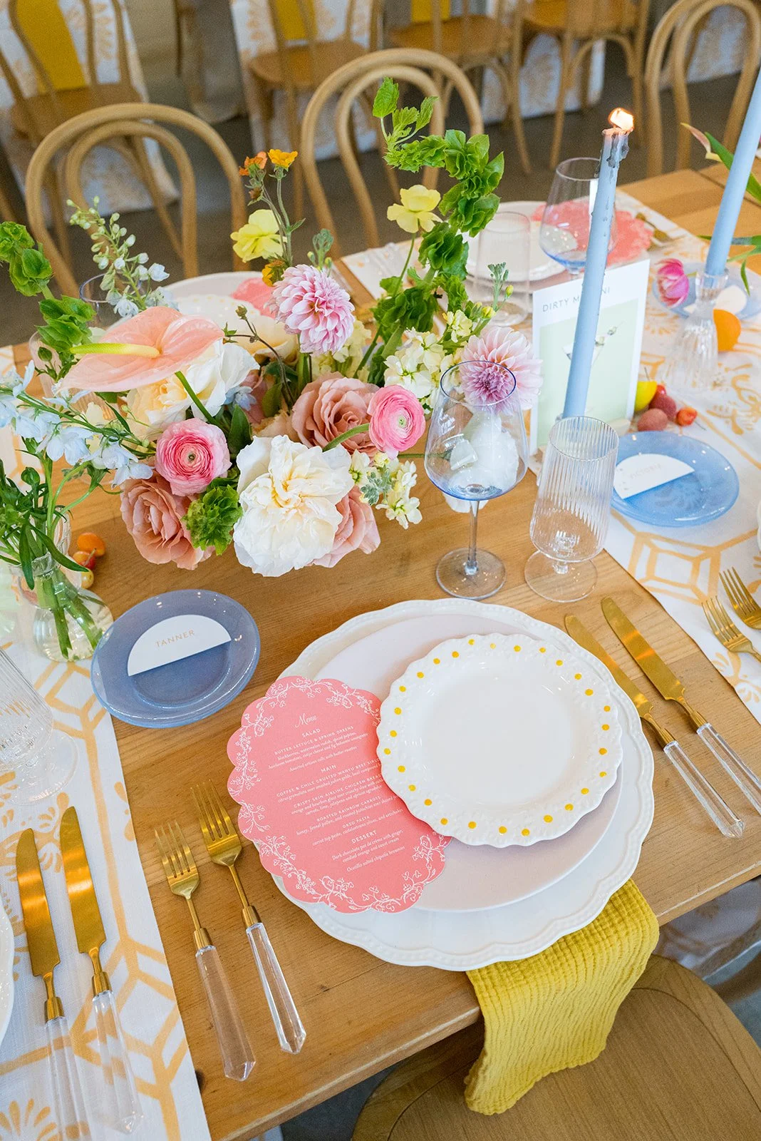 Pink and yellow spring wedding tabletop design with daisy plates and scalloped menu by wedding planners austin tx near me
