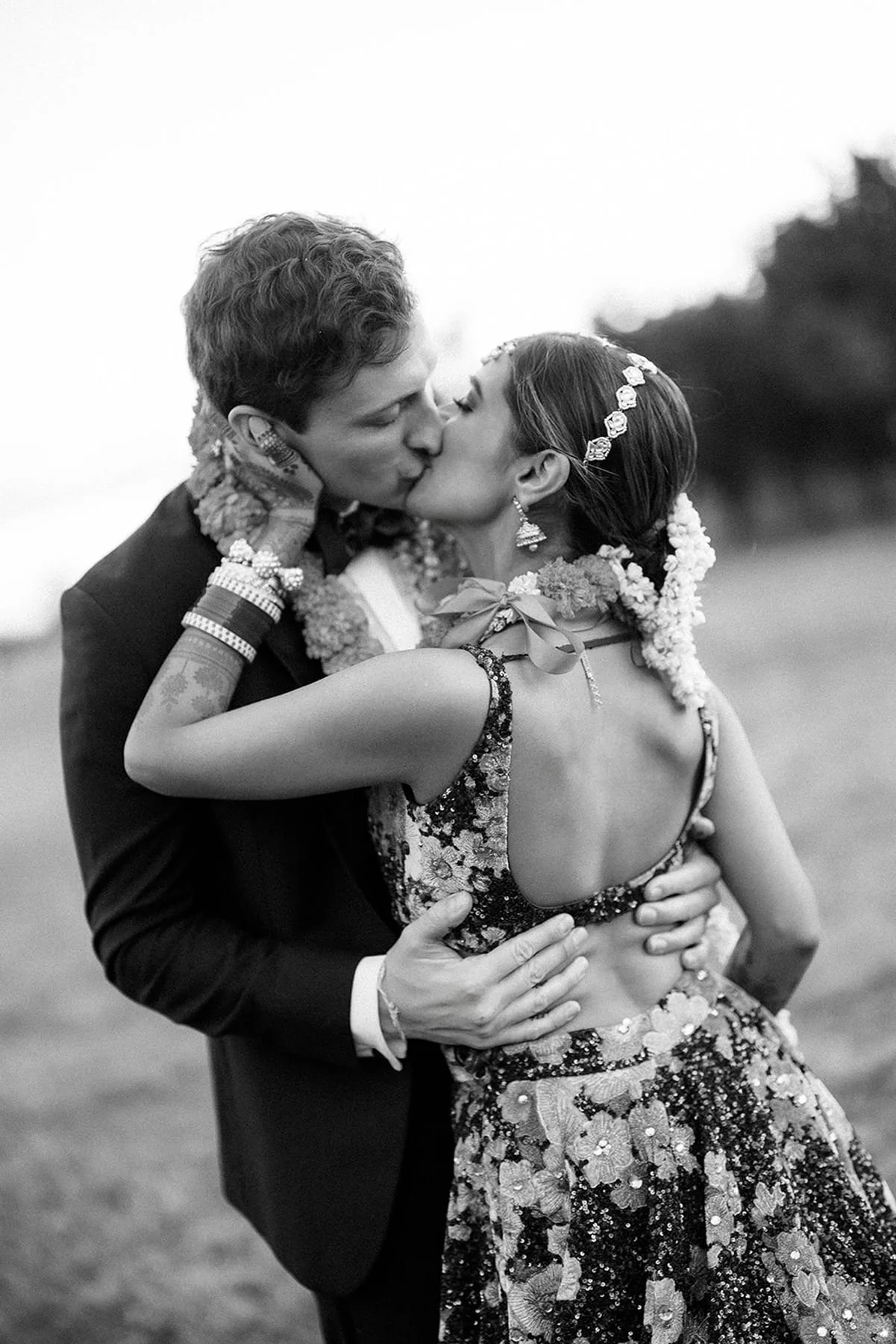 Bride and groom kissing after ceremony - groom in a tuxedo - Indian bride in a traditional Hindu wedding dress by designer sabyasachi - wedding planner austin tx