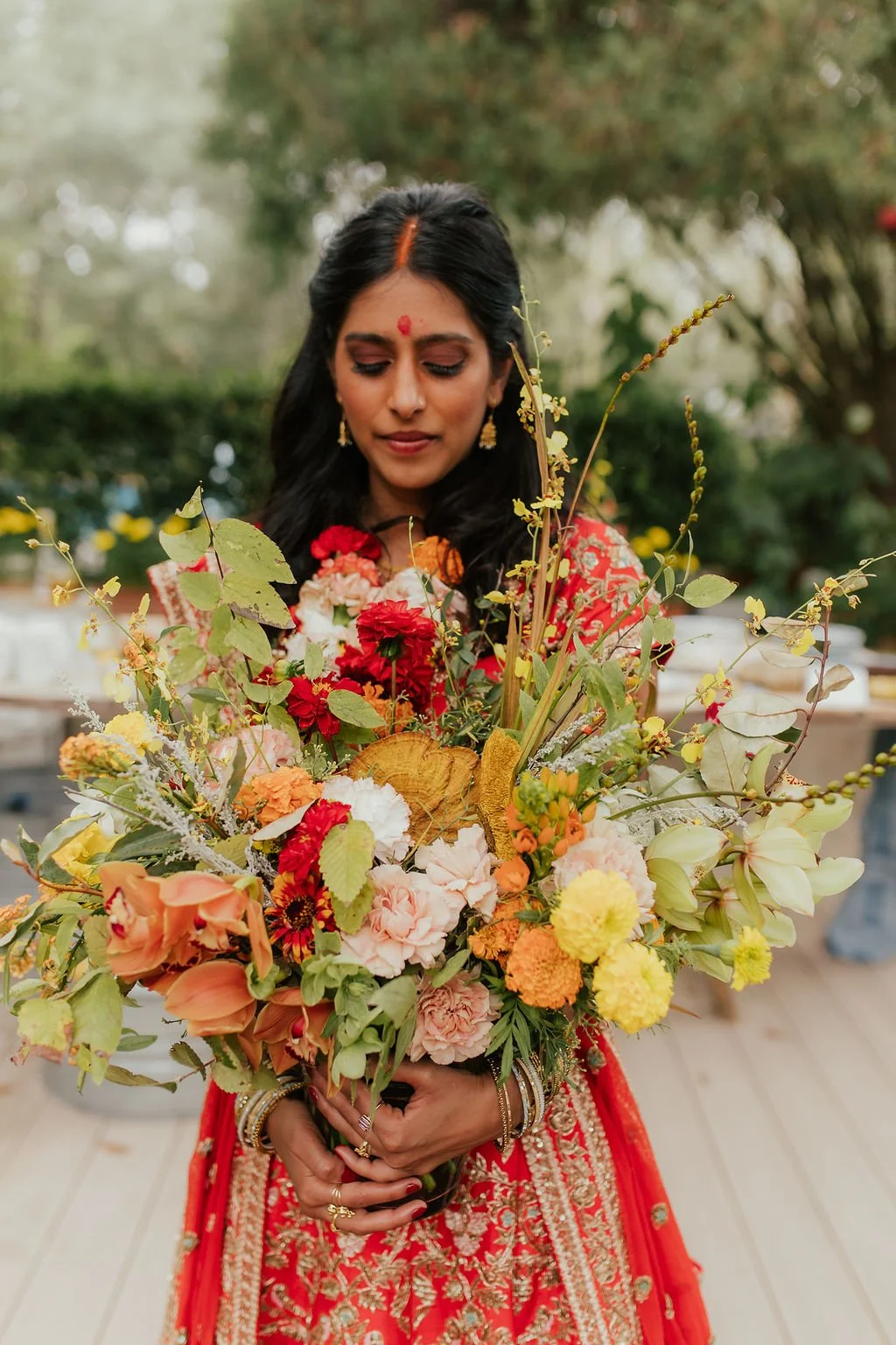Southeast Asian bride for a Hindu fusion wedding by austin tx wedding planners near me red, yellow, orange pink wedding