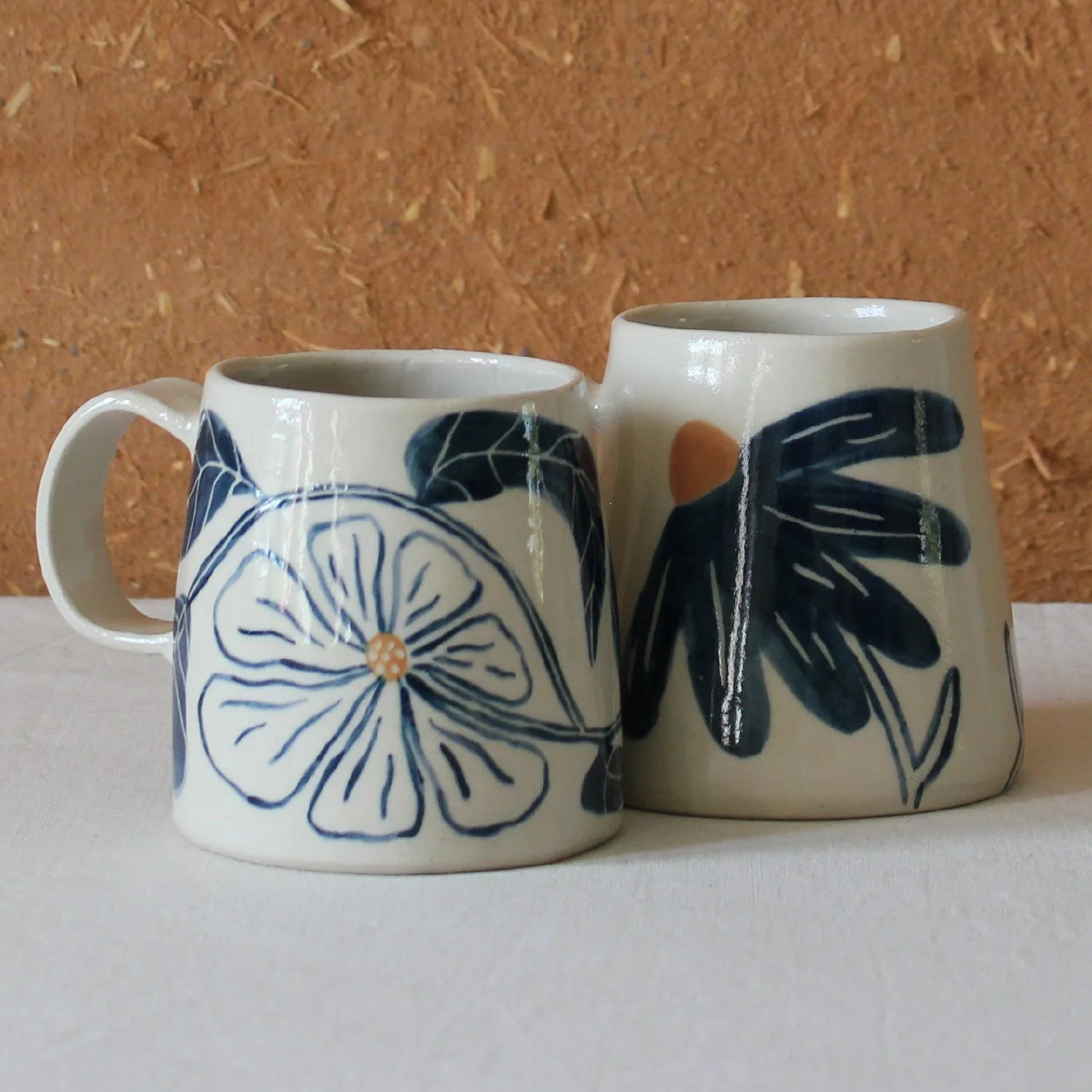  Vue de profil de deux tasses à anse conique à base large, en grès, motif Floral et Fleurs sauvage, création artisanale à Nanteau-sur-Lunain 
