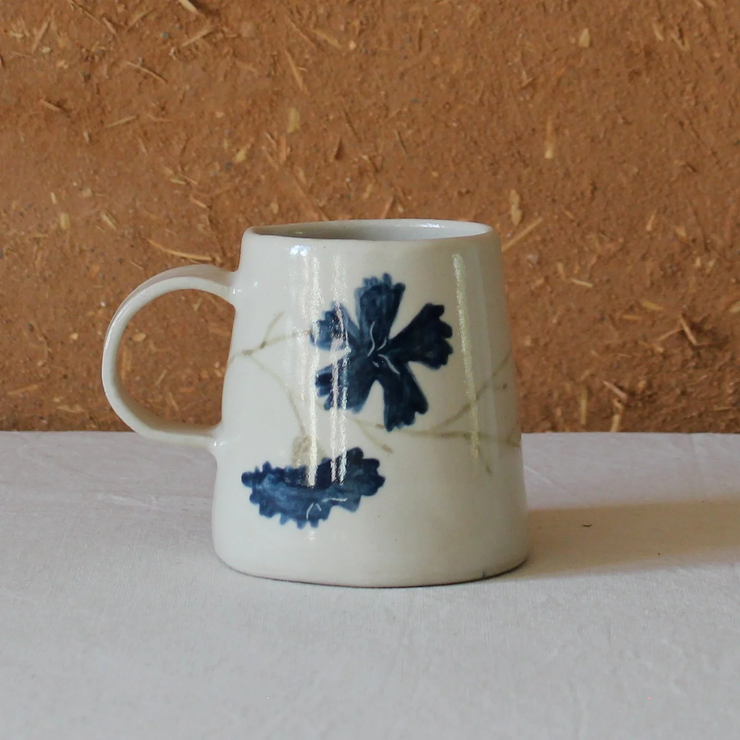 Vue de profil d’une tasse à anse conique à base large, en grès, motif Bleuet, création artisanale à Nanteau-sur-Lunain 