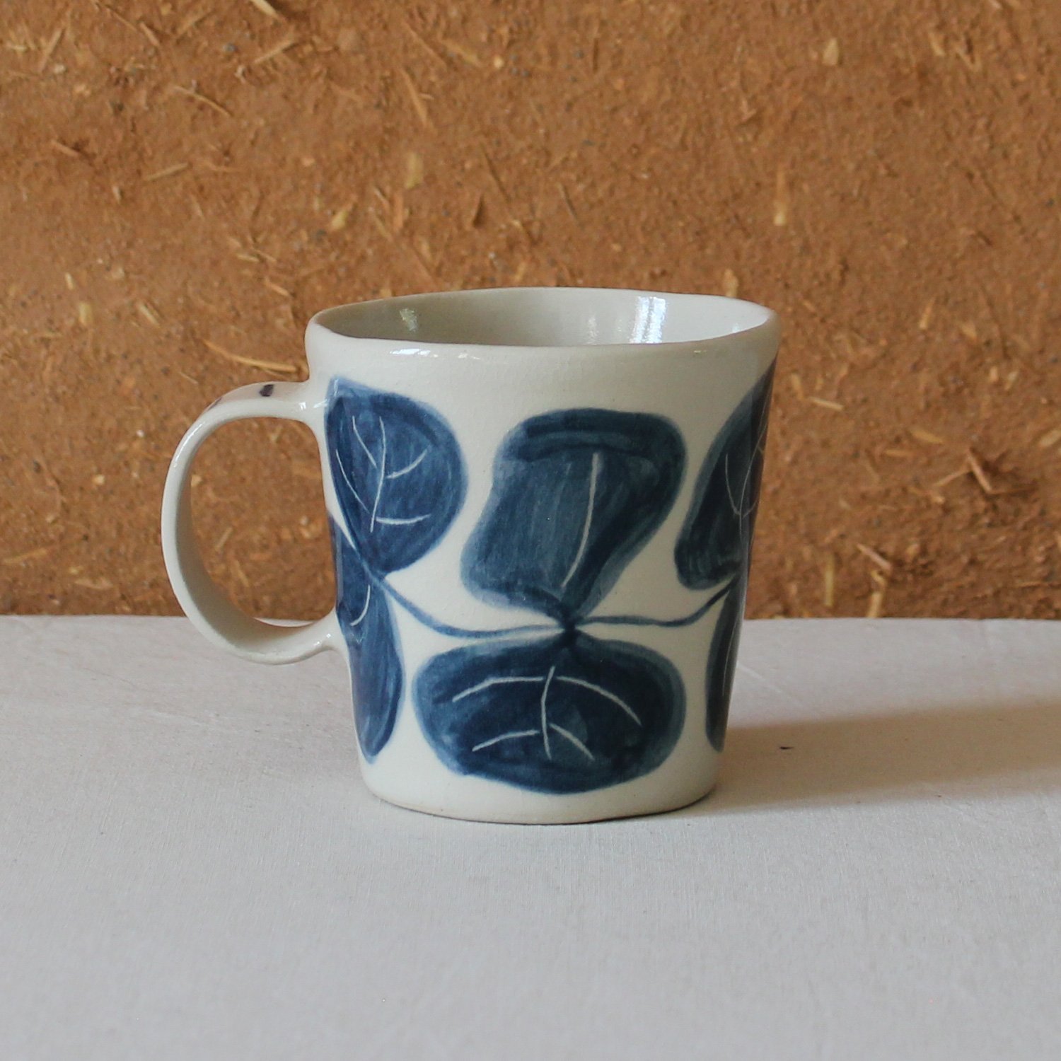  Vue de profil d’une tasse à anse conique à base étroite, en grès, motif Eucalyptus, création artisanale à Nanteau-sur-Lunain 
