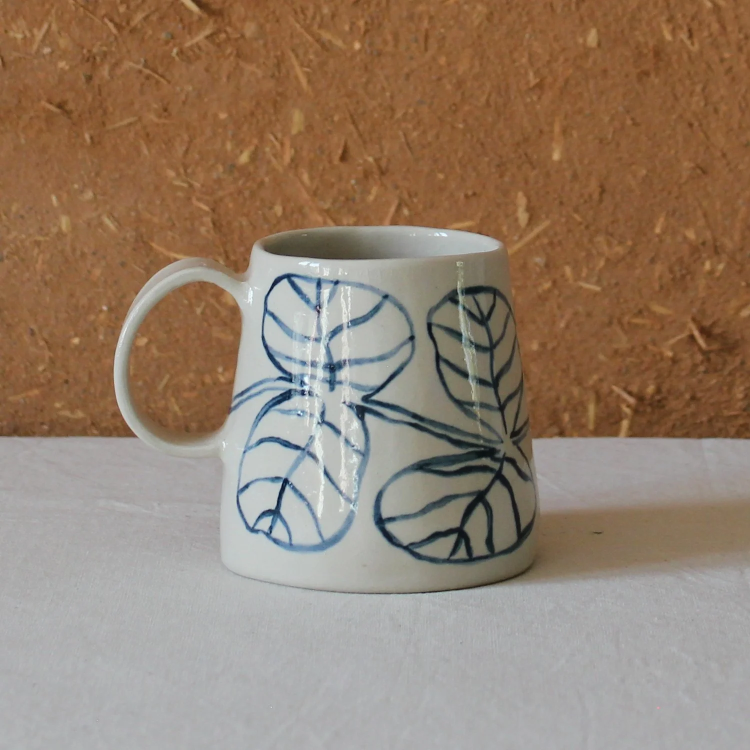  Vue de profil d’une tasse à anse conique à base large, en grès, motif Eucalyptus, création artisanale à Nanteau-sur-Lunain 