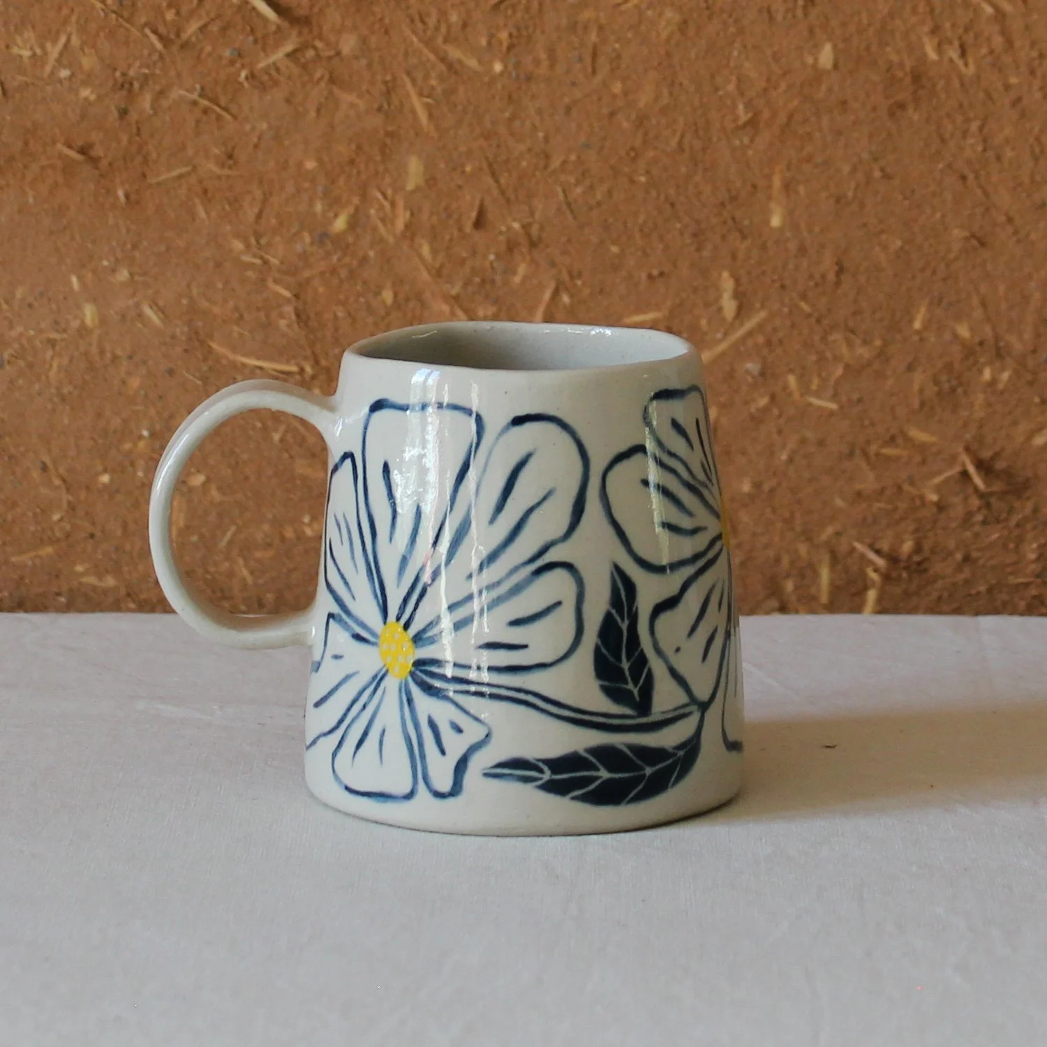  Vue de profil d’une tasse à anse conique à base large, en grès, motif Floral, création artisanale à Nanteau-sur-Lunain 